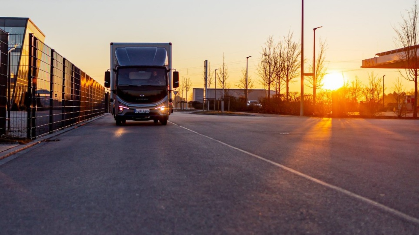 Ein von Quantron vom Diesel- auf Elektroantrieb umgerüsteter Lkw fährt in den Sonnenuntergang. Foto: Quantron