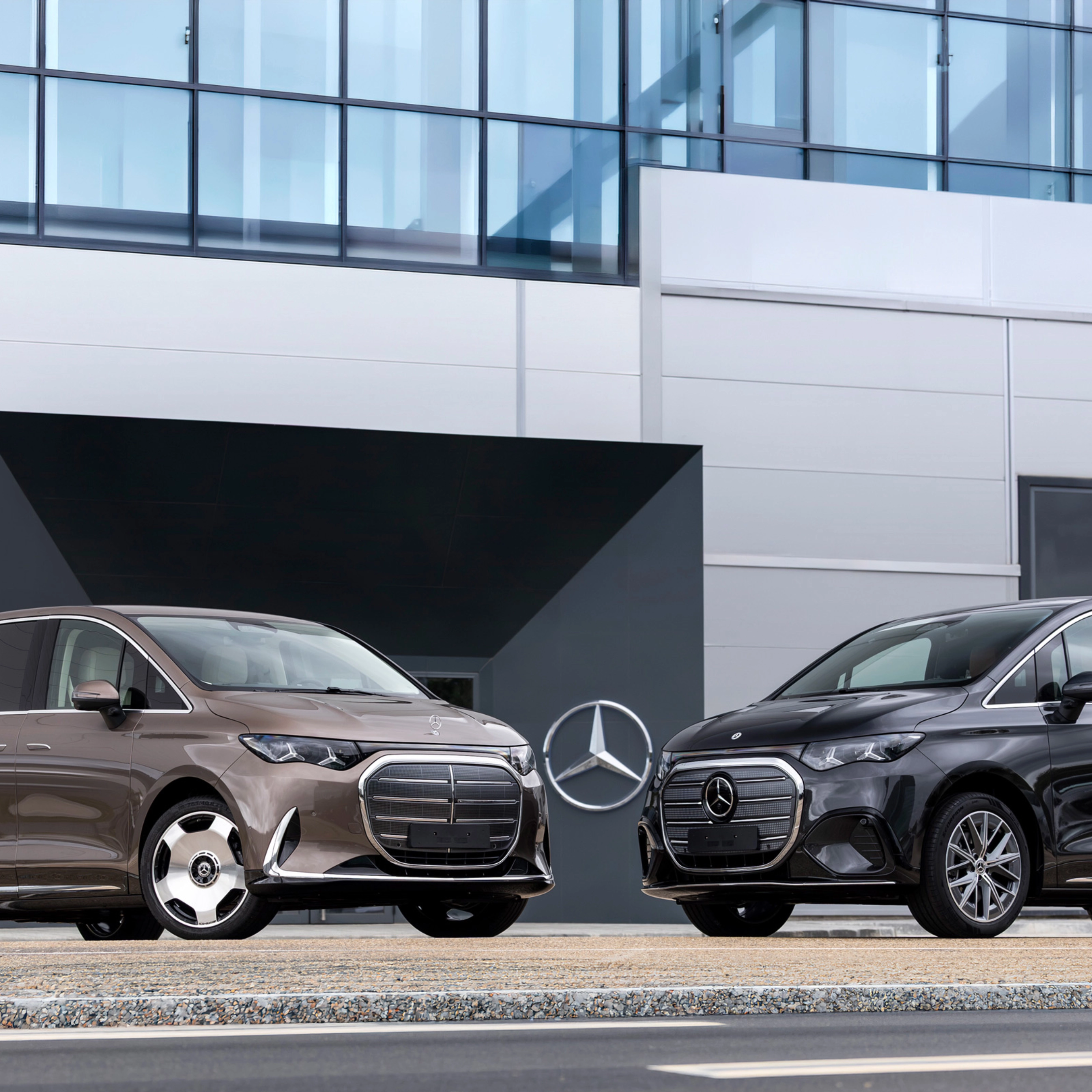 Zwei Mercedes-Benz Vans vor einem modernen Bürogebäude.