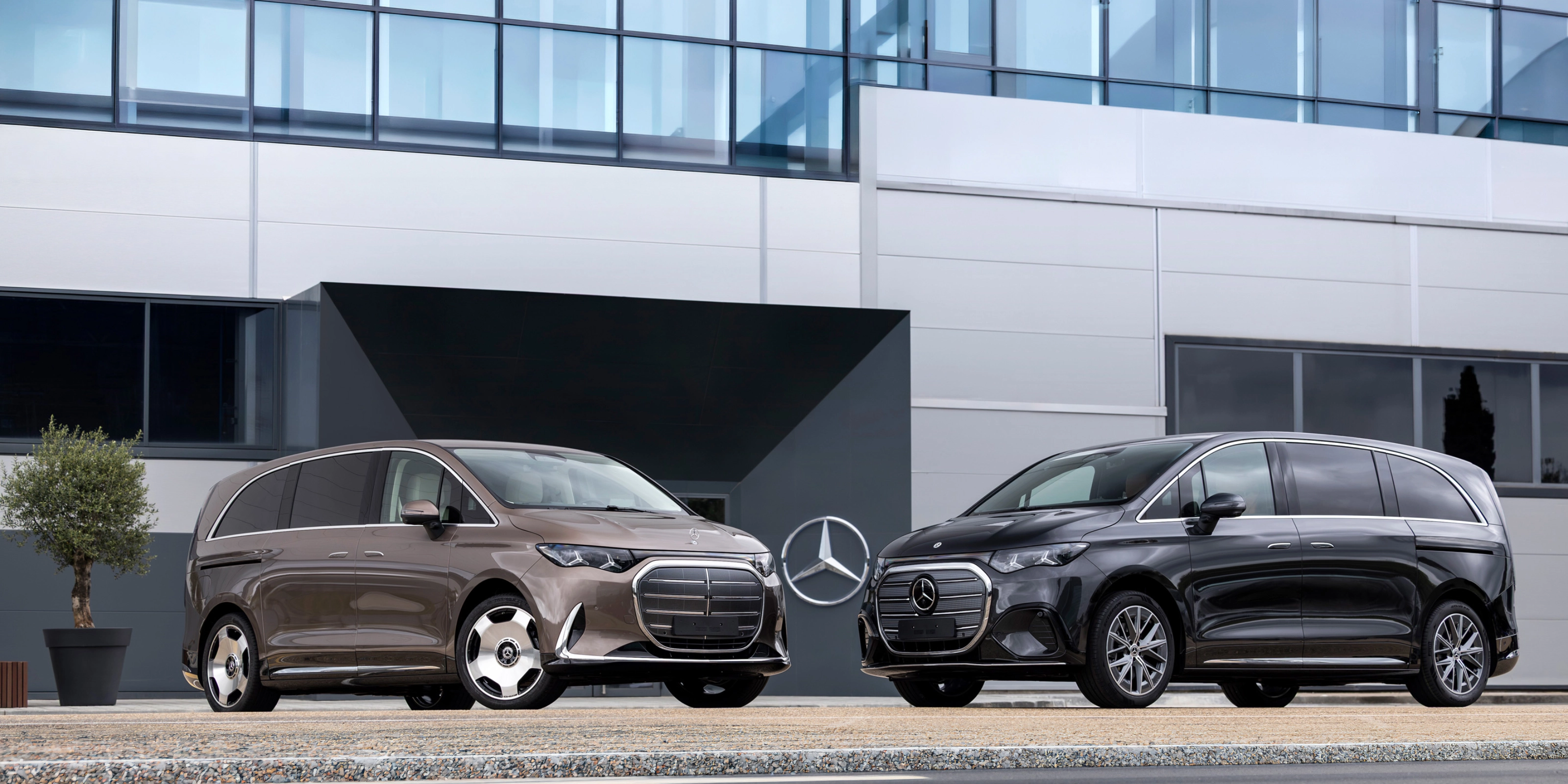 Zwei Mercedes-Benz Vans vor einem modernen Bürogebäude.