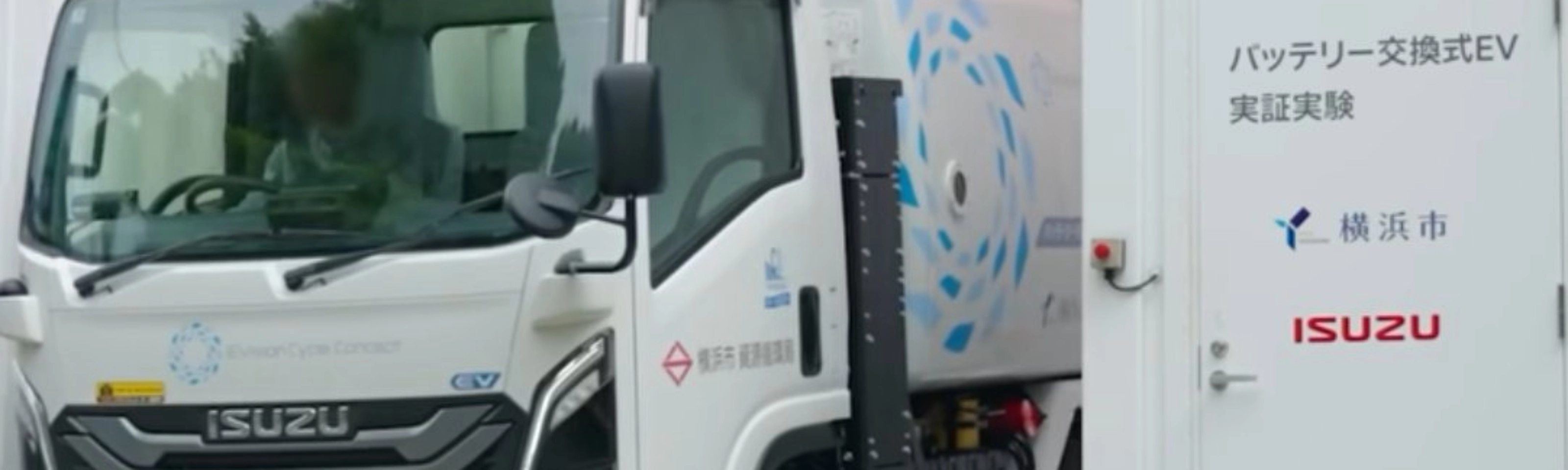 Isuzu truck displayed at an exhibition beside an information board.