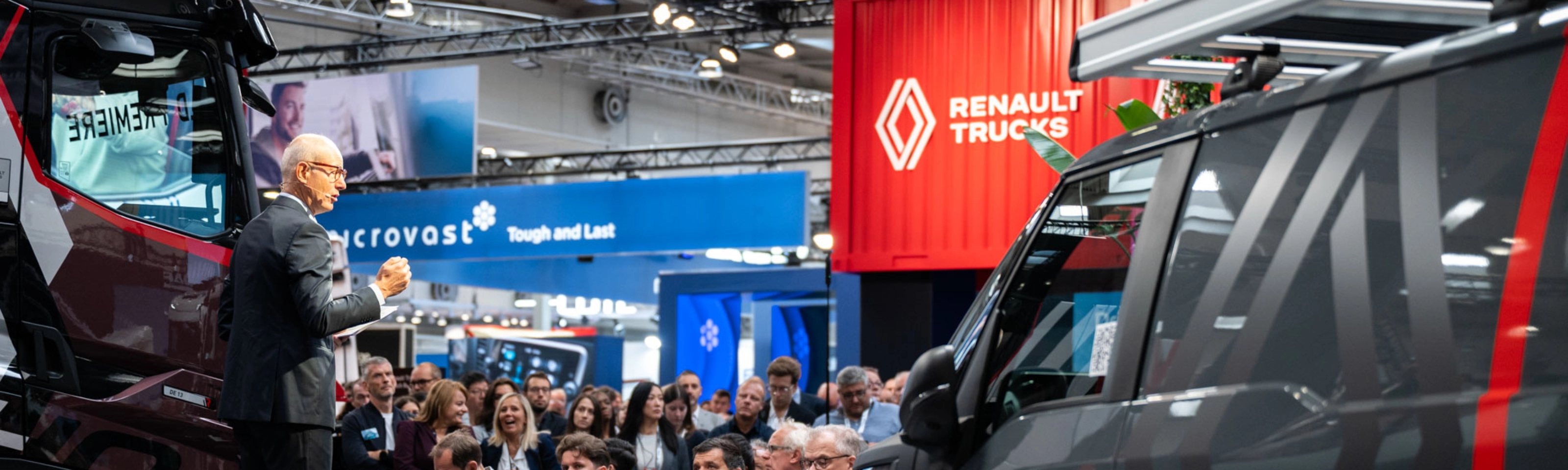 Nutzfahrzeuge und Besucher in einer gut besuchten Messehalle der IAA Transportation.