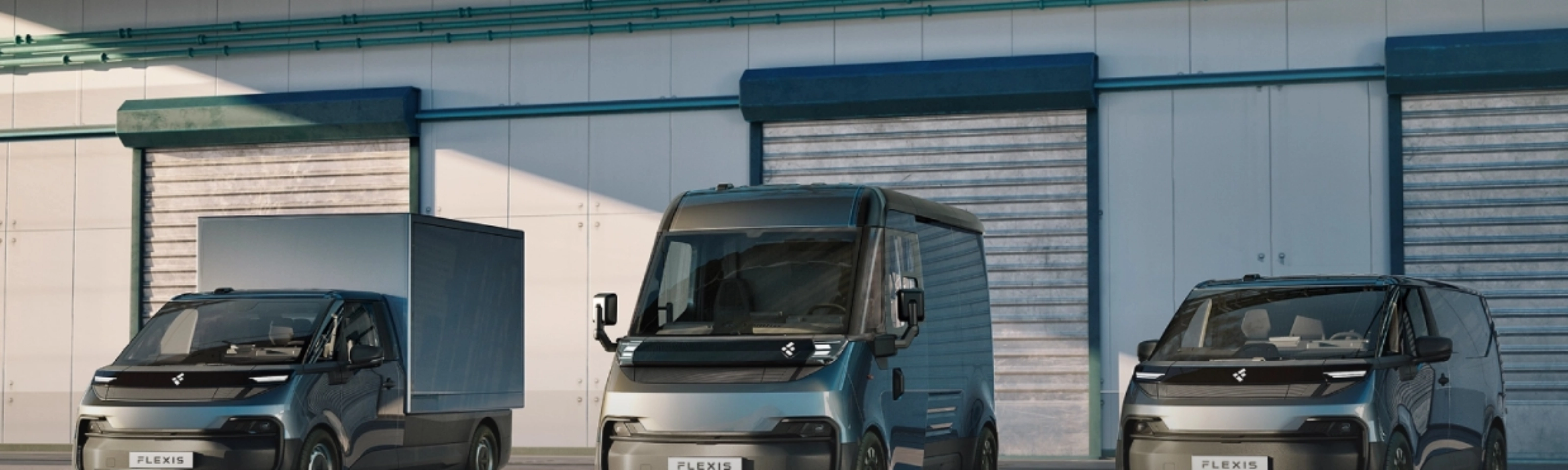 Three FLEXIS electric delivery vans parked in front of a warehouse.