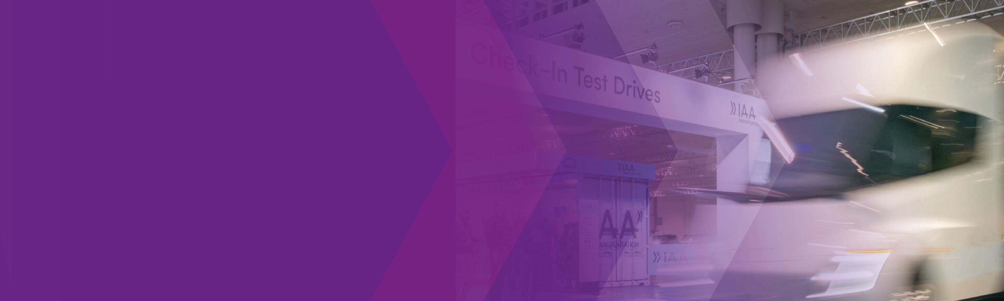 Blurred white truck at the IAA test drive area with a purple graphic overlay.