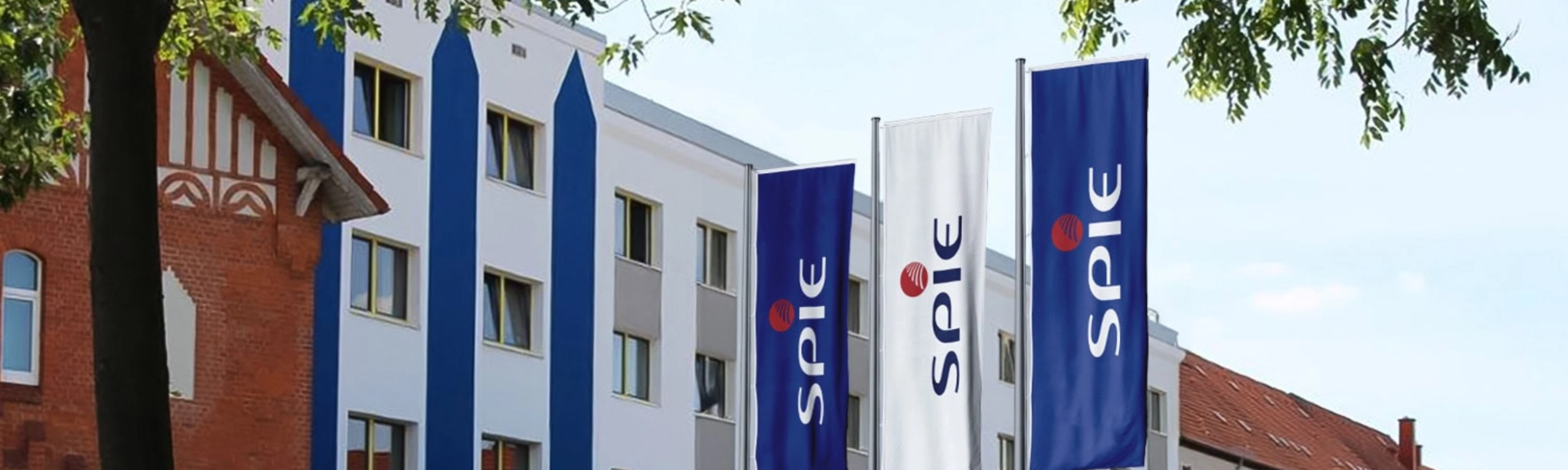 SPIE company building with blue SPIE flags displayed along the facade.