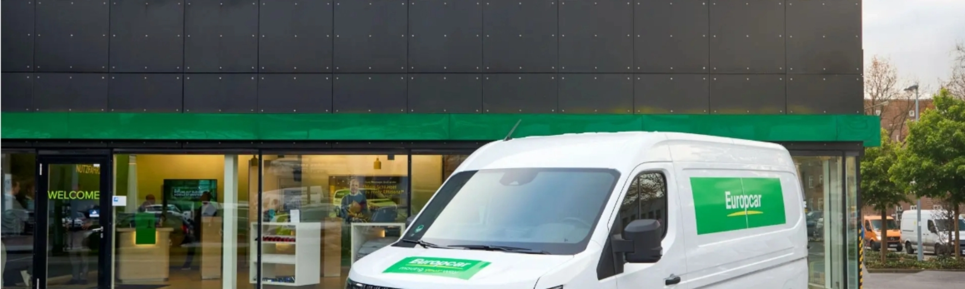 Elektro-Van von Europcar steht vor einem Europcar-Mietzentrum für Transporter und Lkw.