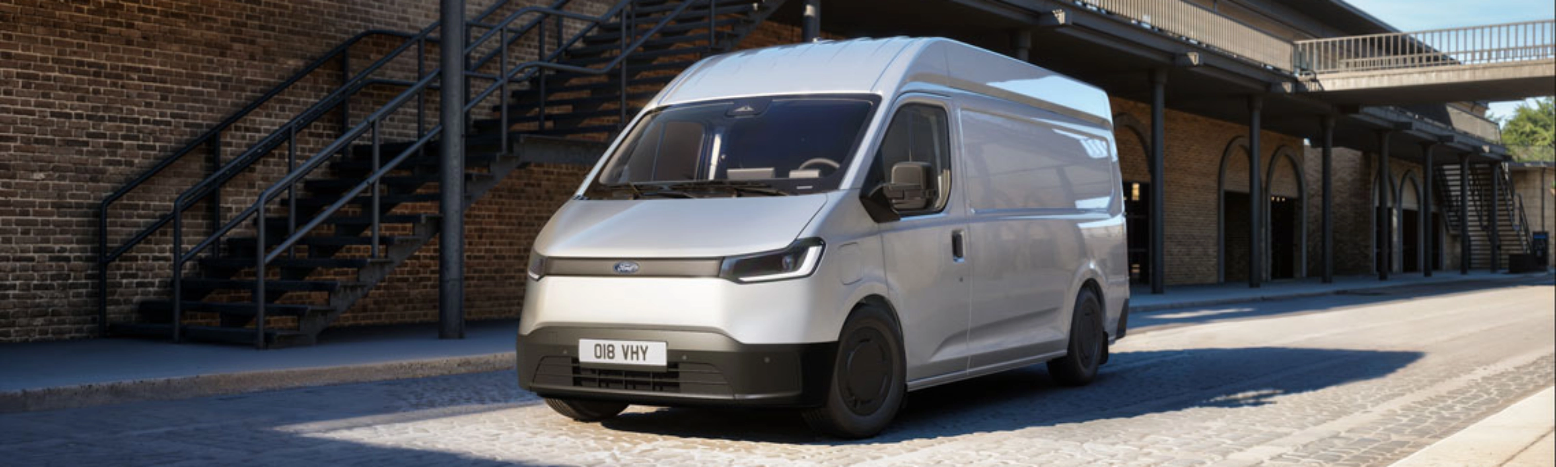 White van parked in a courtyard in front of a brick building