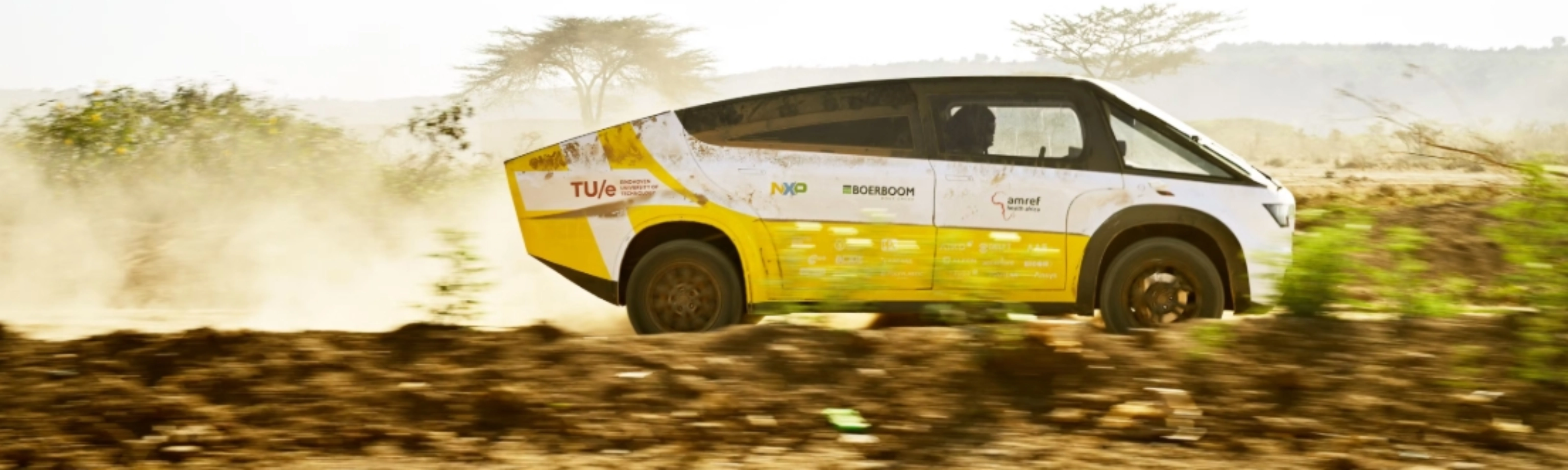 Fahrzeug des Solar Team Eindhoven fährt auf einer staubigen unbefestigten Straße.