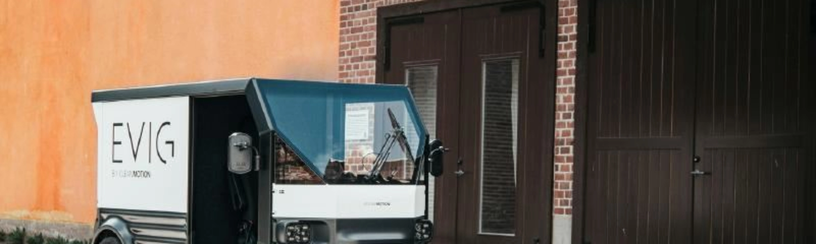 CleanMotion EVIG electric cargo vehicle parked beside a building.