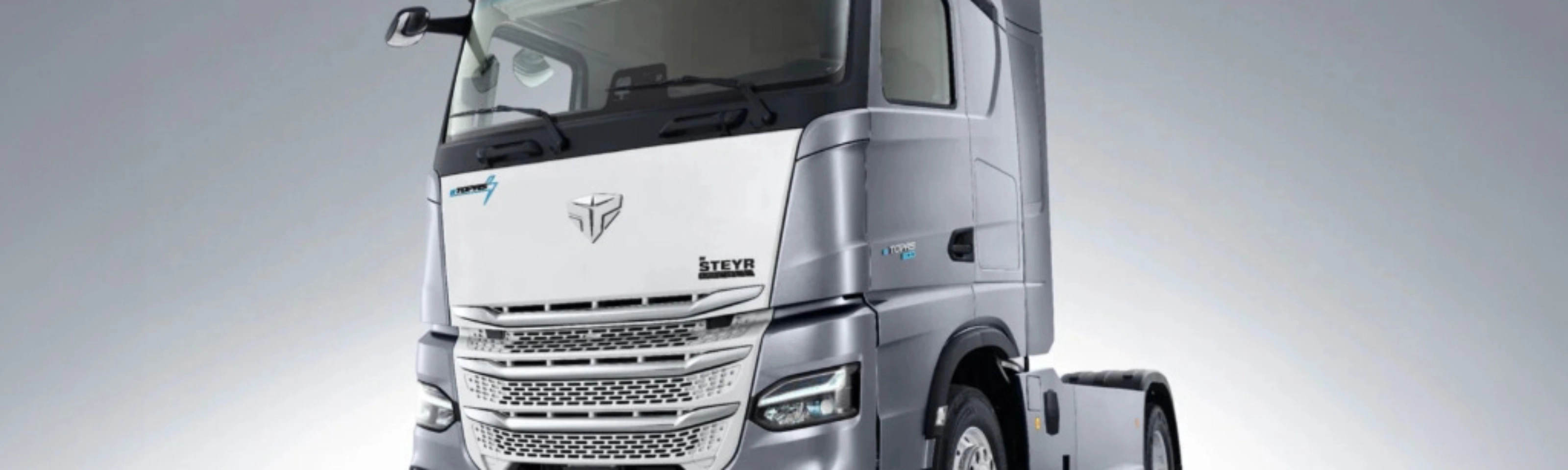 Silver Steyr semi-truck cab in studio view from the front left.