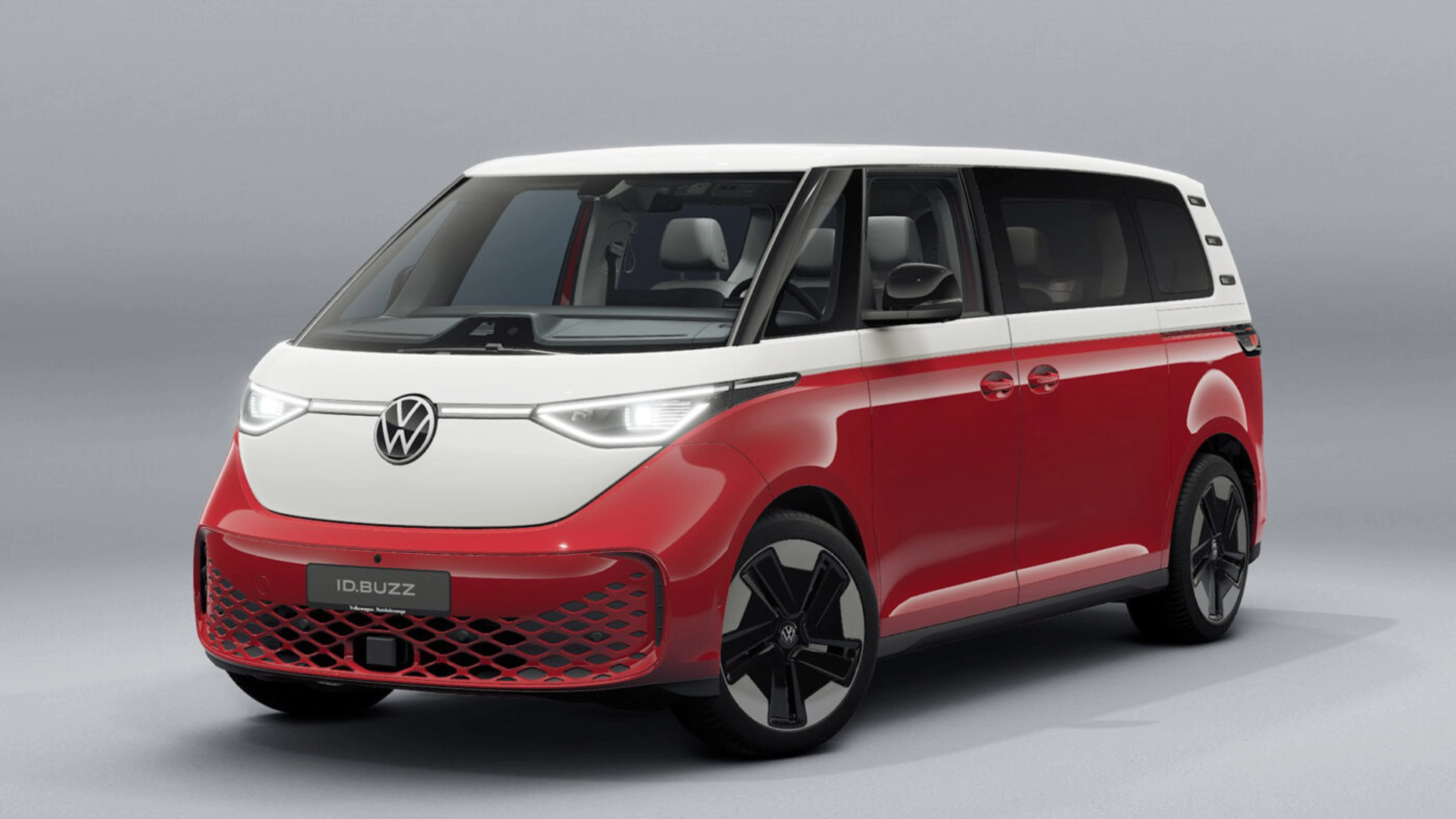 Red and white Volkswagen van in front view on a neutral studio background.