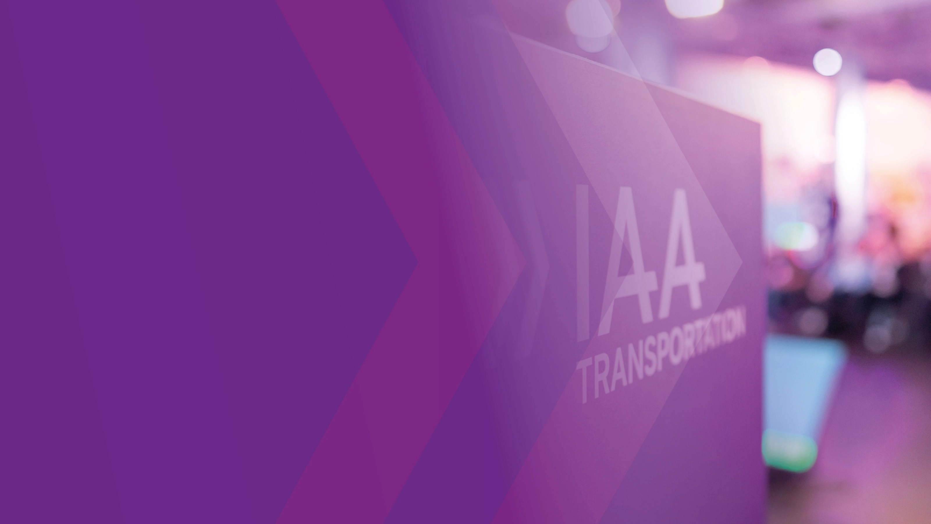 Schild mit der Aufschrift „IAA TRANSPORTATION“ auf einer Messe, lila Gestaltung im Vordergrund.