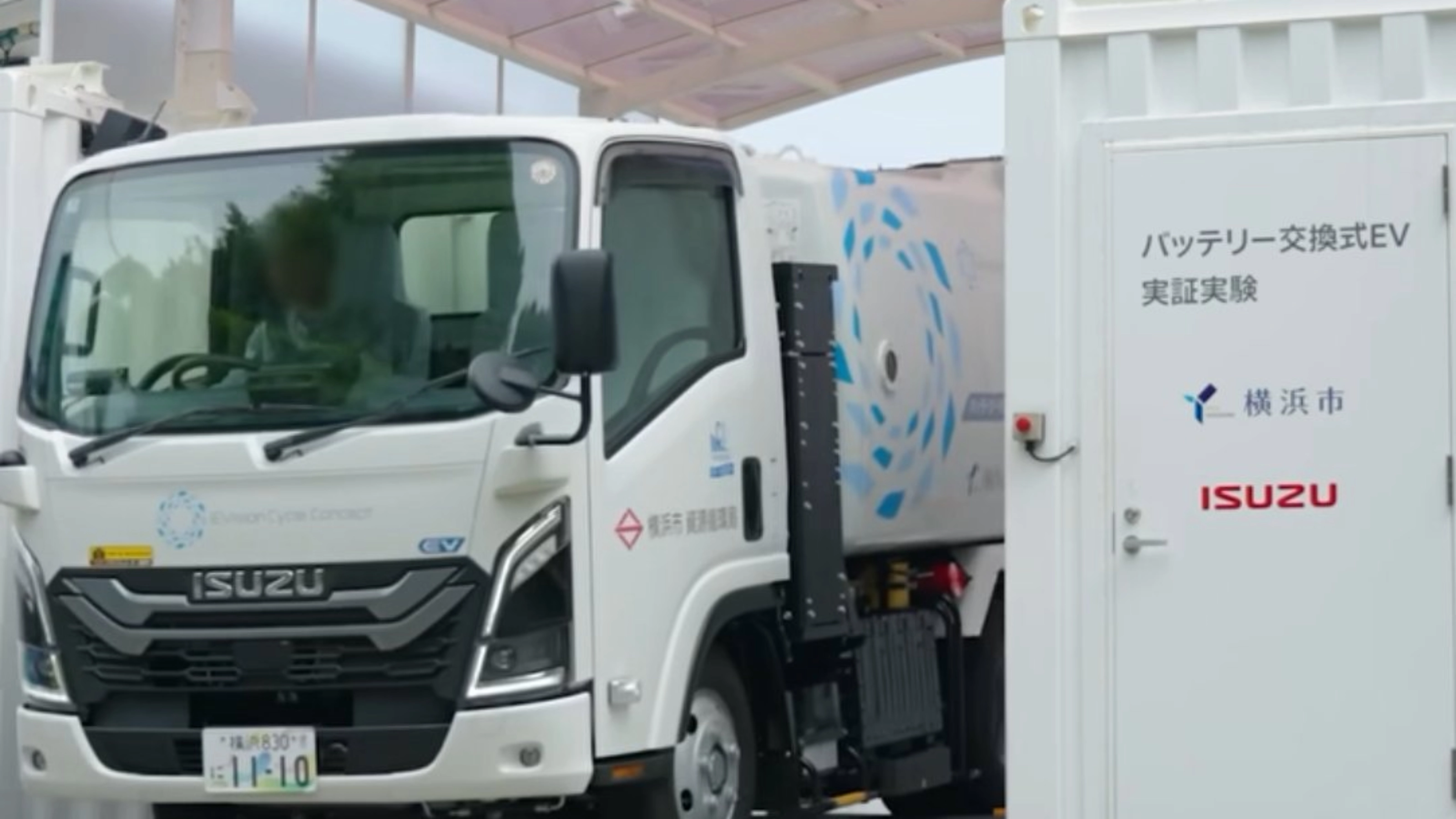 Isuzu truck displayed at an exhibition beside an information board.