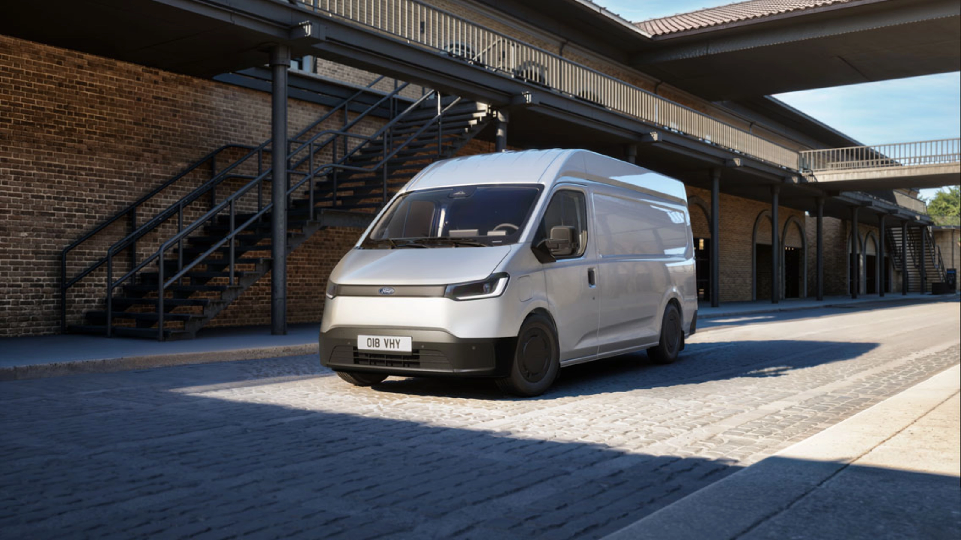 White van parked in a courtyard in front of a brick building