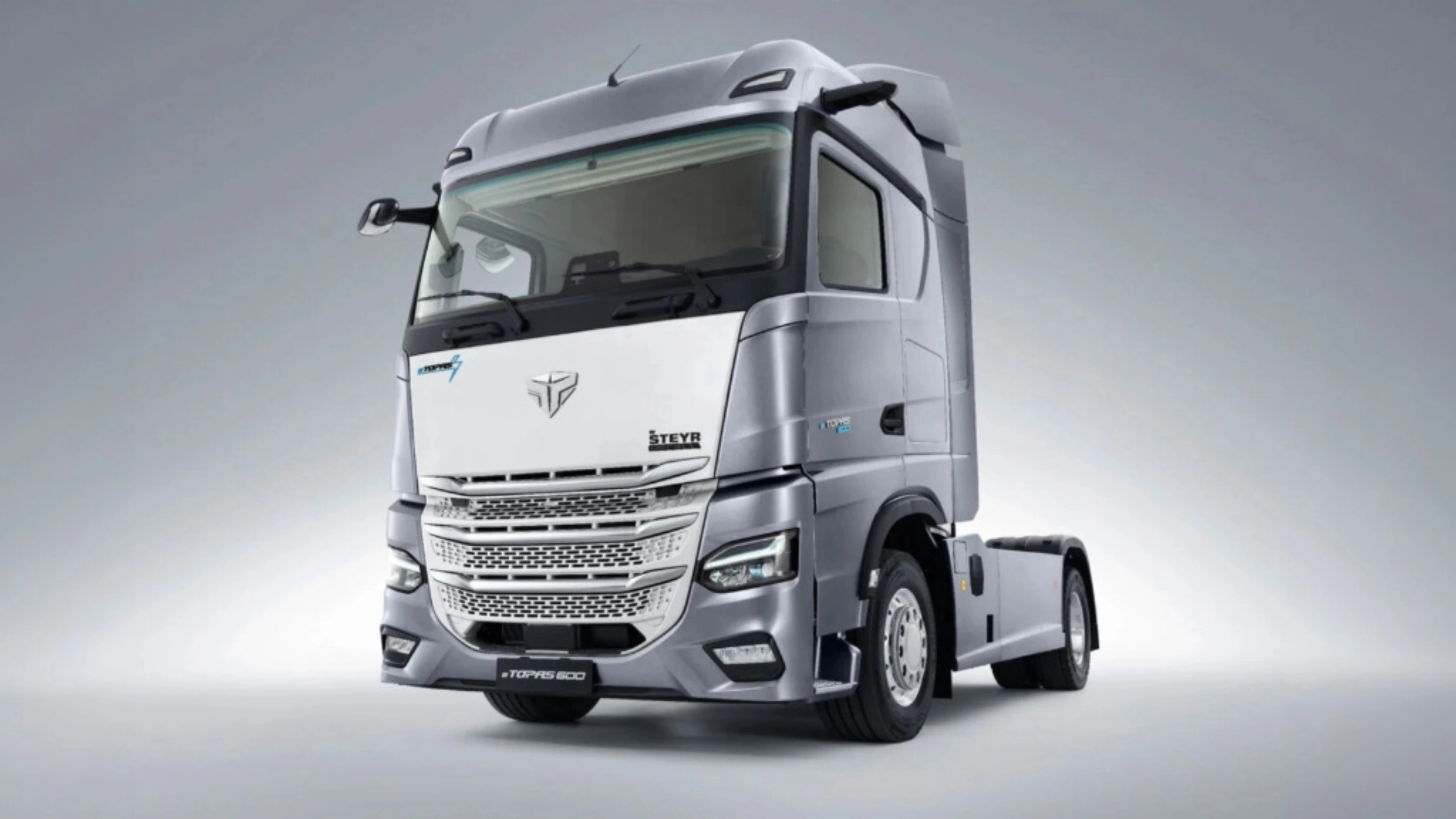 Silver Steyr semi-truck cab in studio view from the front left.