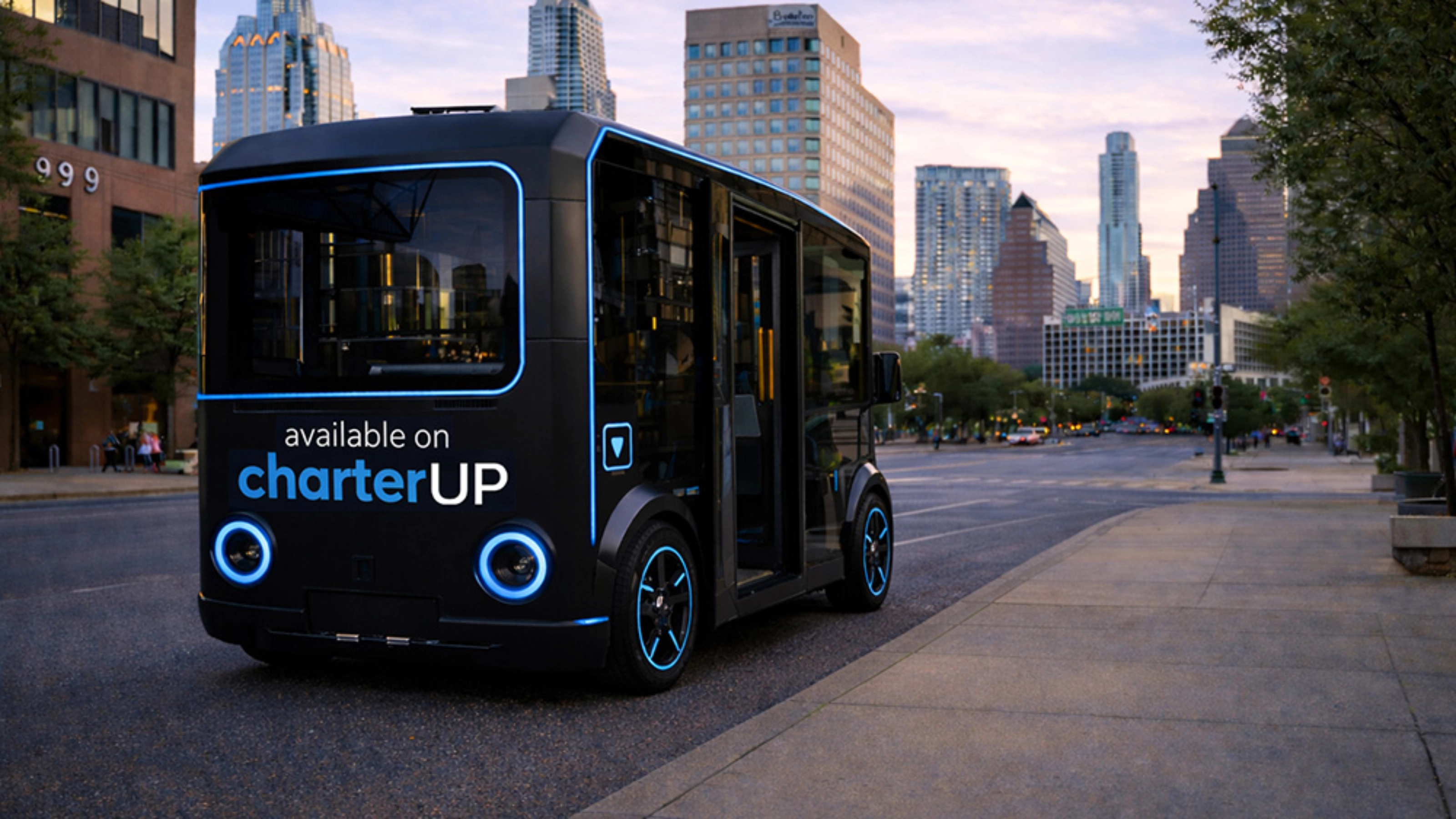Small black electric shuttle bus with CharterUP logo in city street.