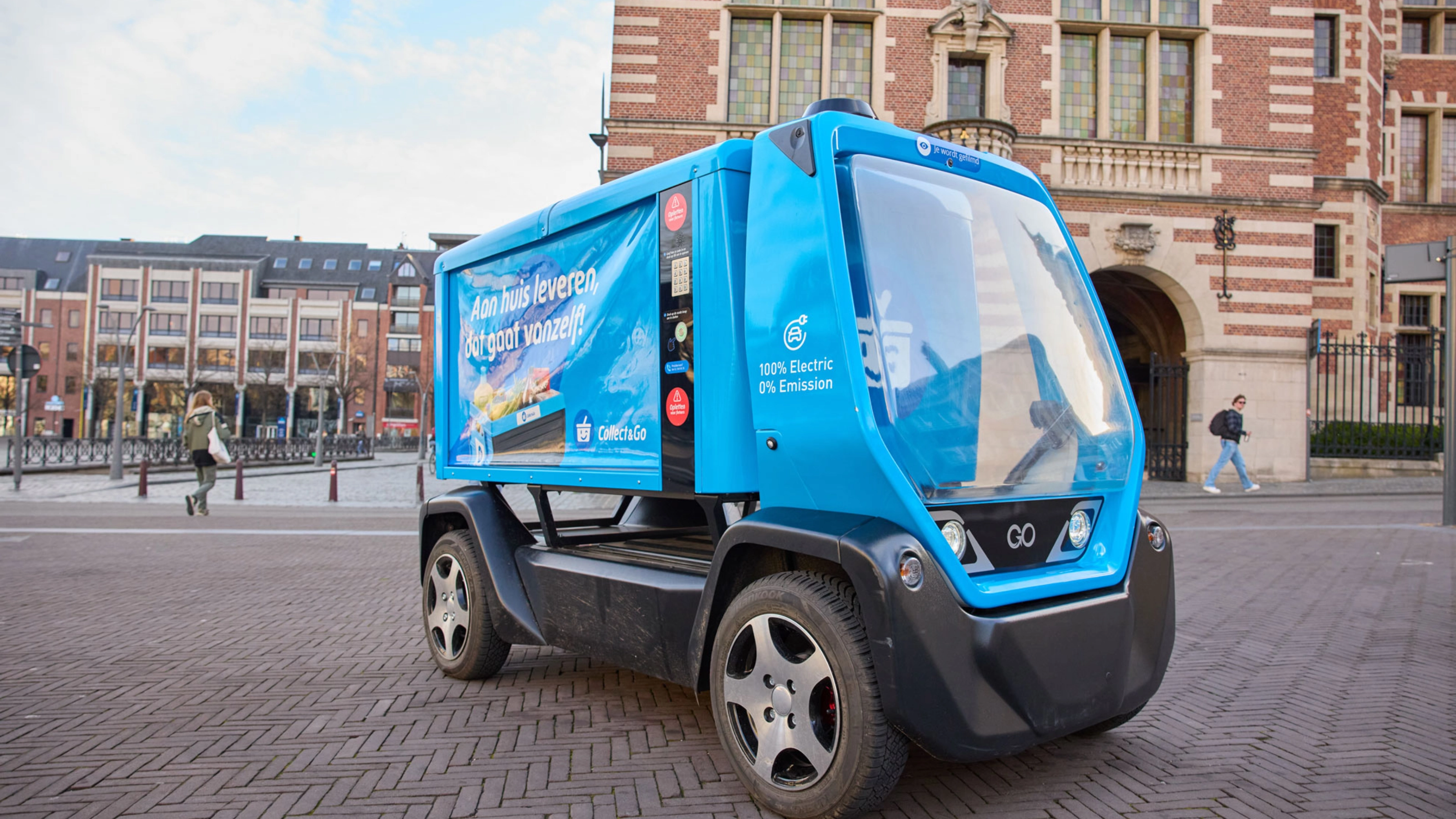Kleines blaues Elektro-Müllfahrzeug auf einem Stadtplatz.