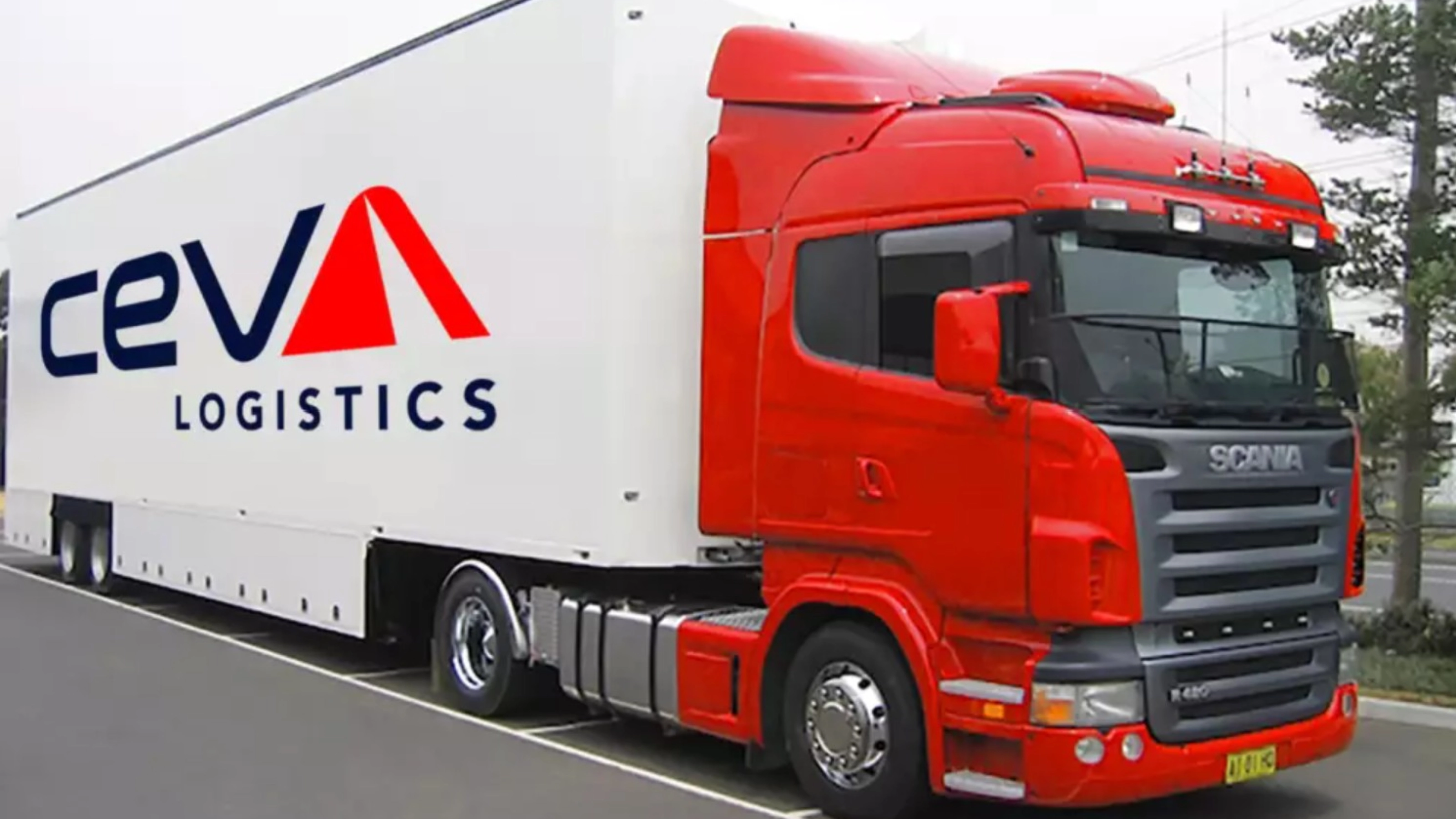 A red CEVA Logistics truck with trailer is parked on a street.
