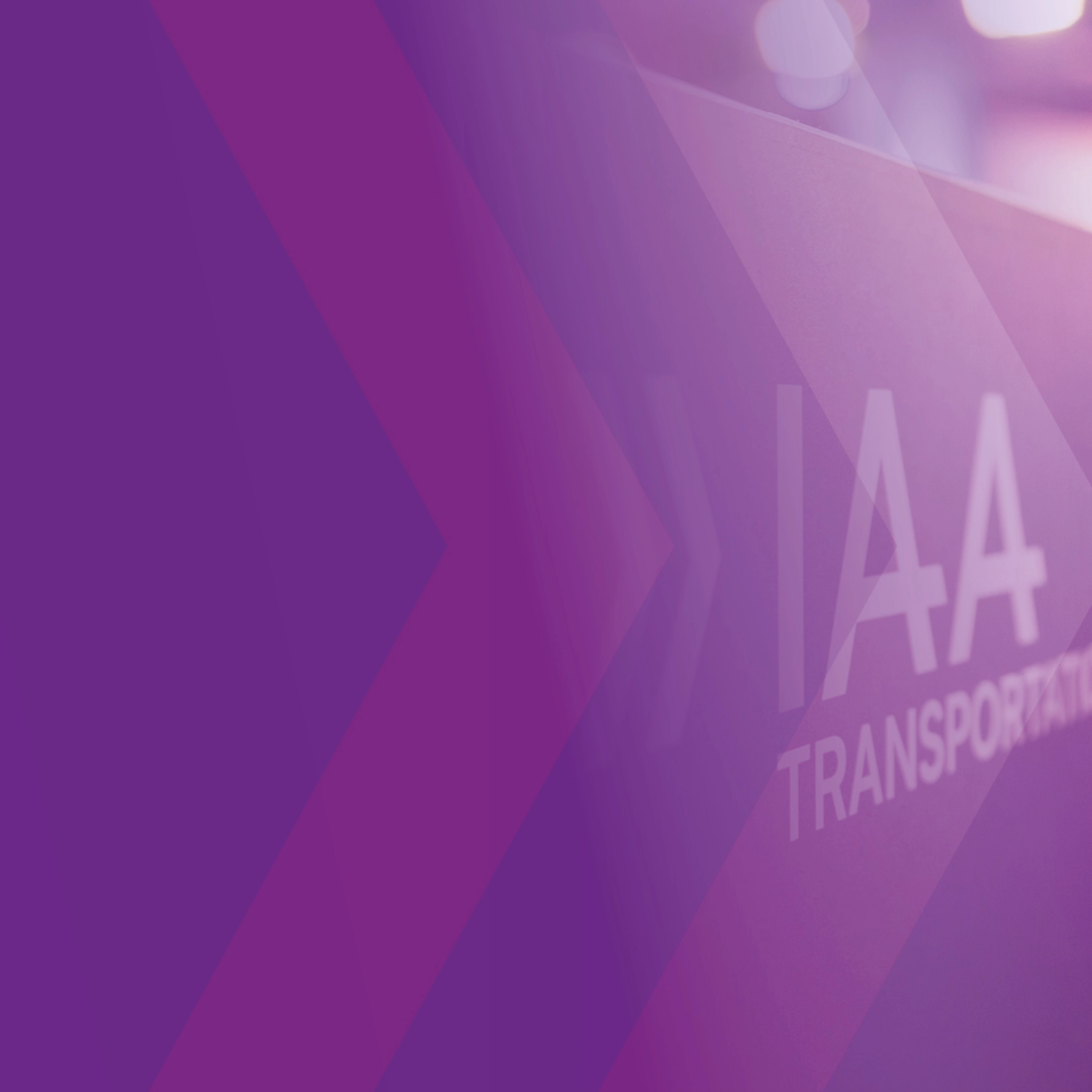 Schild mit der Aufschrift „IAA TRANSPORTATION“ auf einer Messe, lila Gestaltung im Vordergrund.