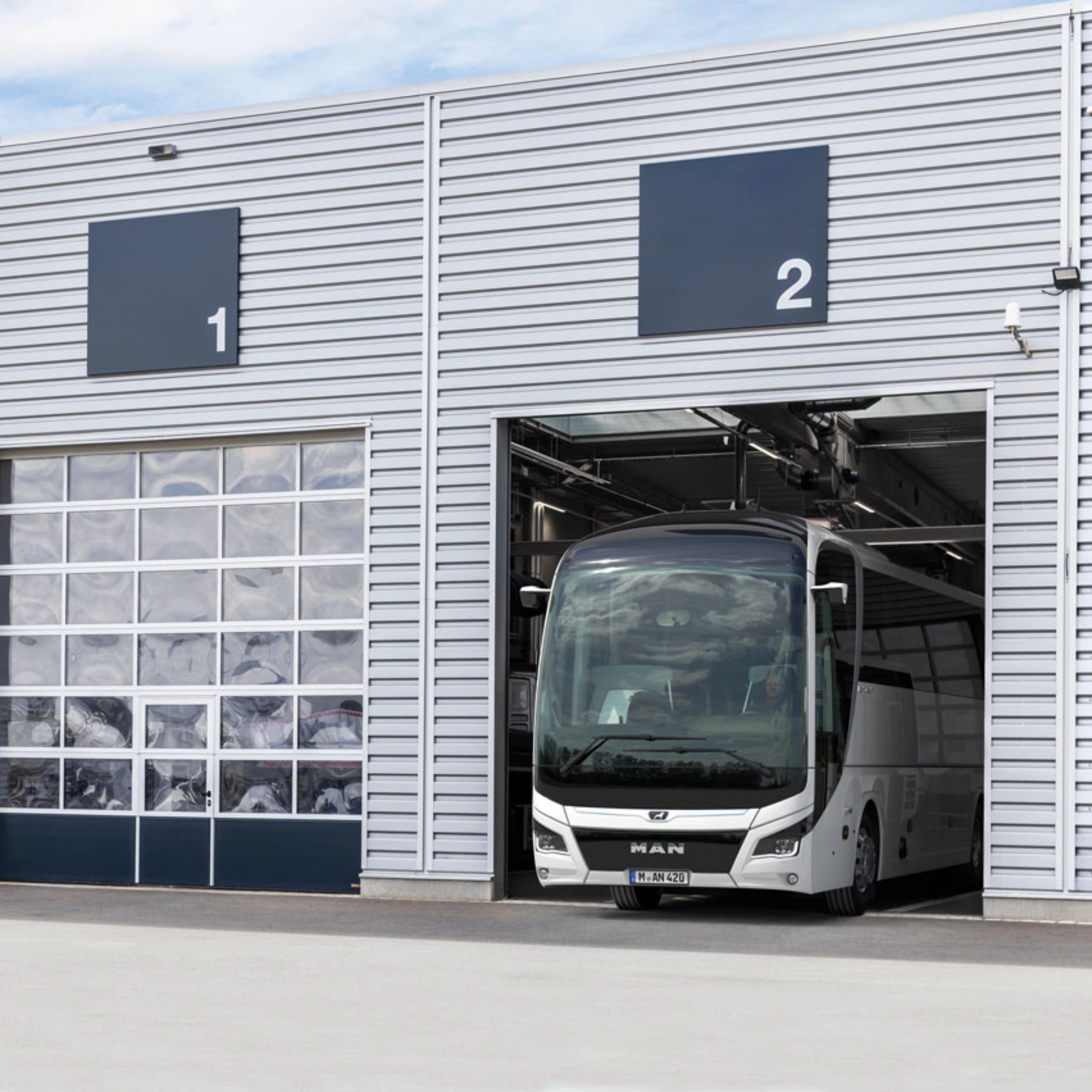 Ein Bus steht in einer nummerierten Garage eines modernen Betriebsgebäudes.