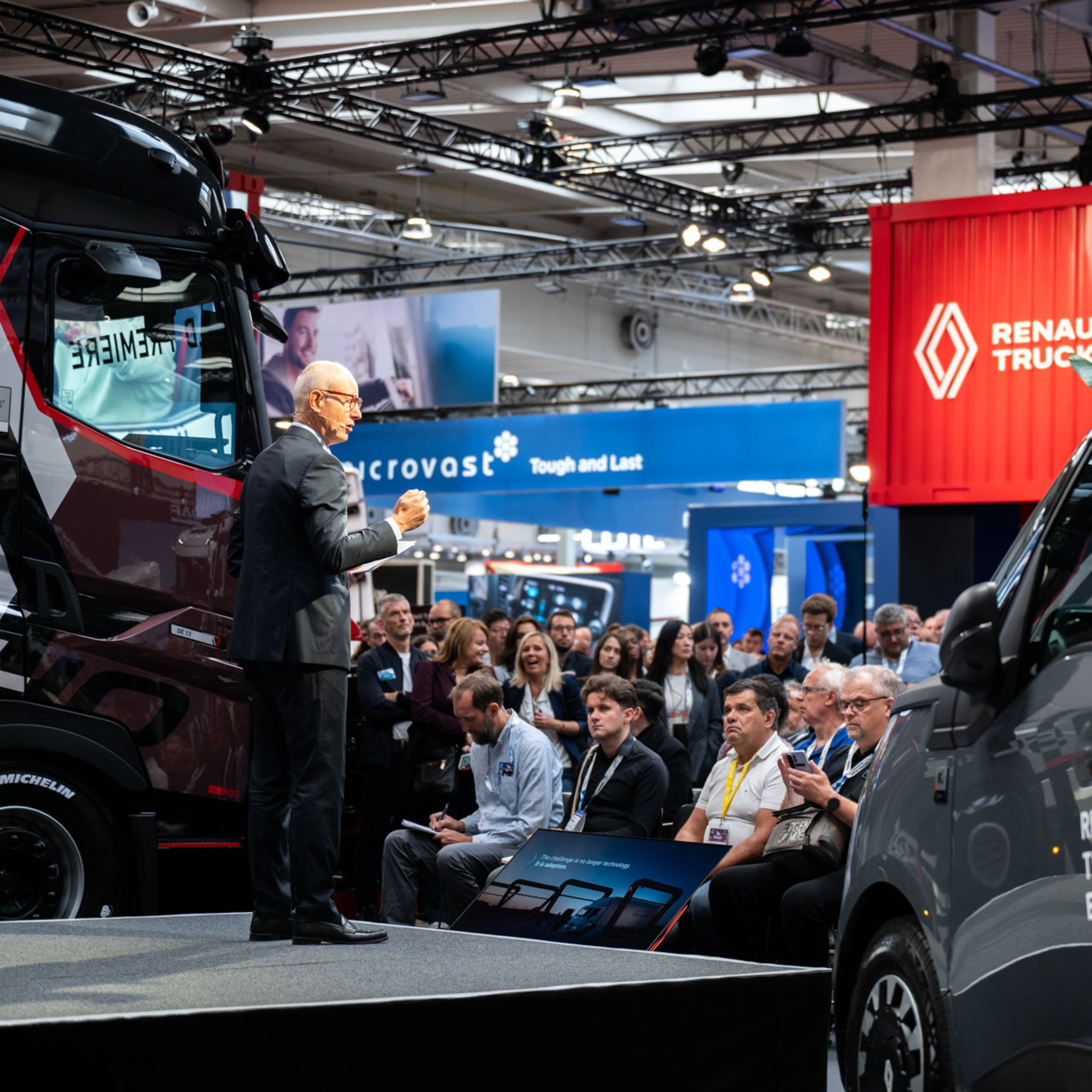 Nutzfahrzeuge und Besucher in einer gut besuchten Messehalle der IAA Transportation.