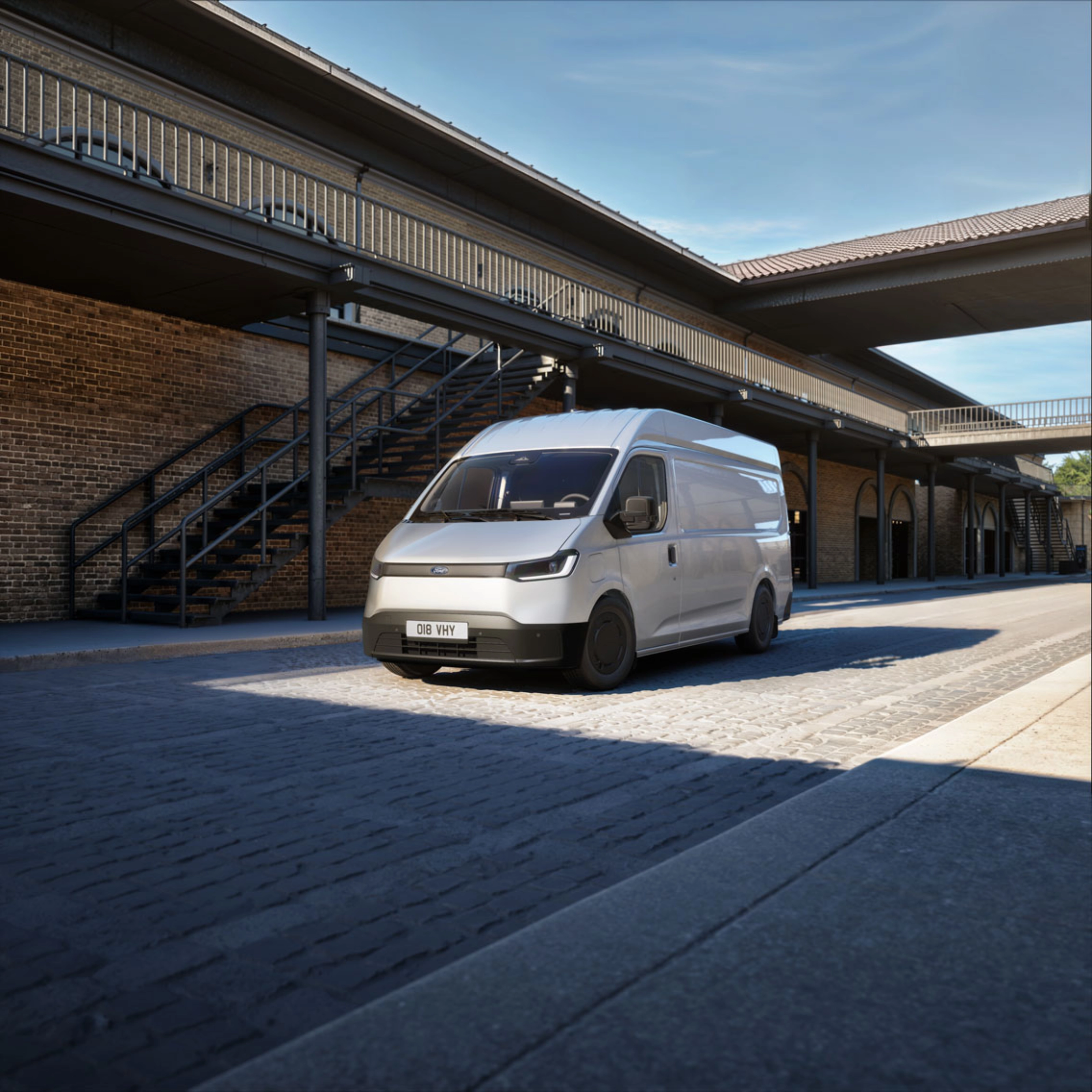 White van parked in a courtyard in front of a brick building