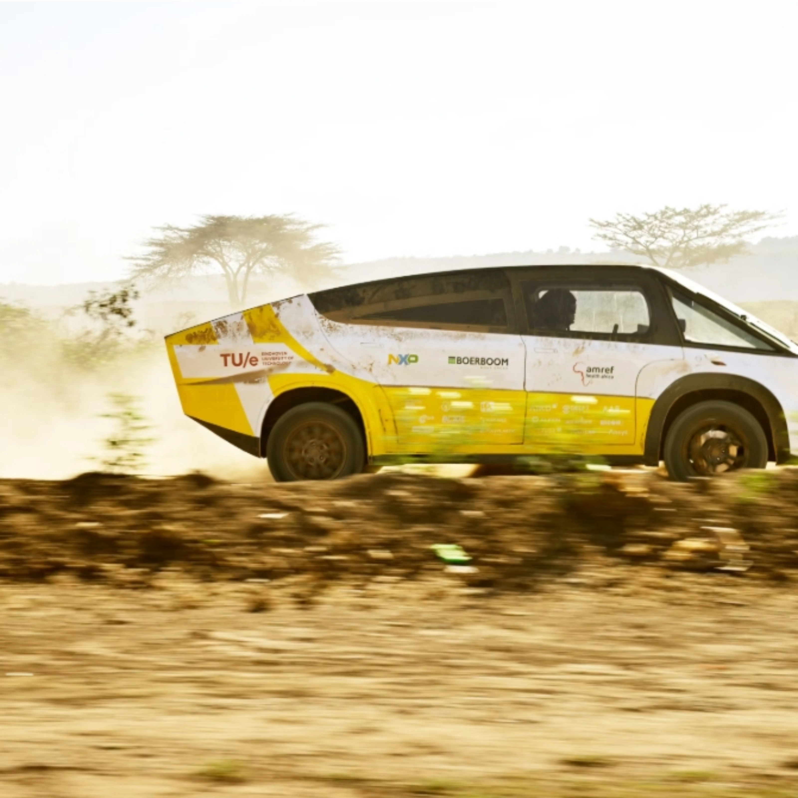 Fahrzeug des Solar Team Eindhoven fährt auf einer staubigen unbefestigten Straße.