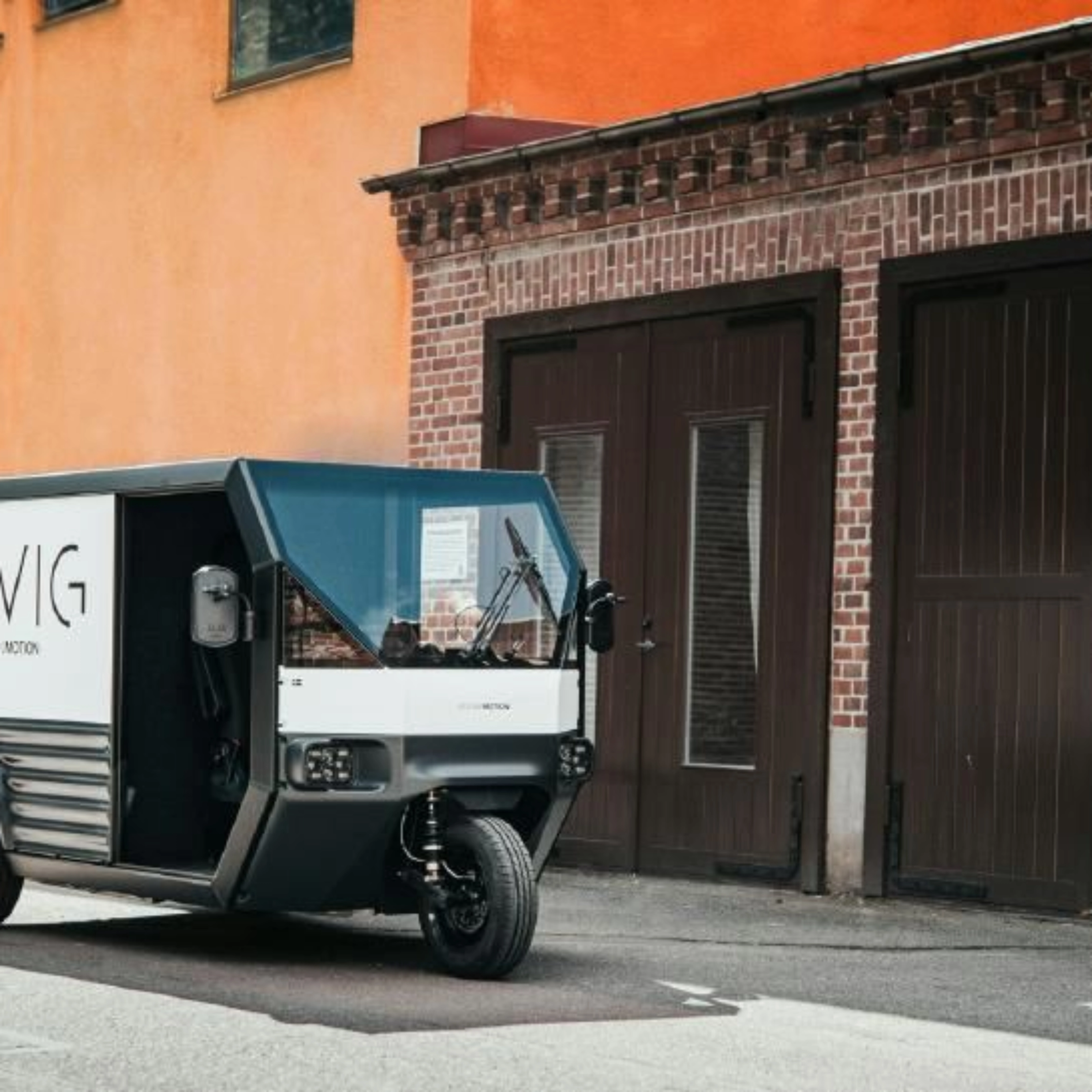 CleanMotion EVIG electric cargo vehicle parked beside a building.