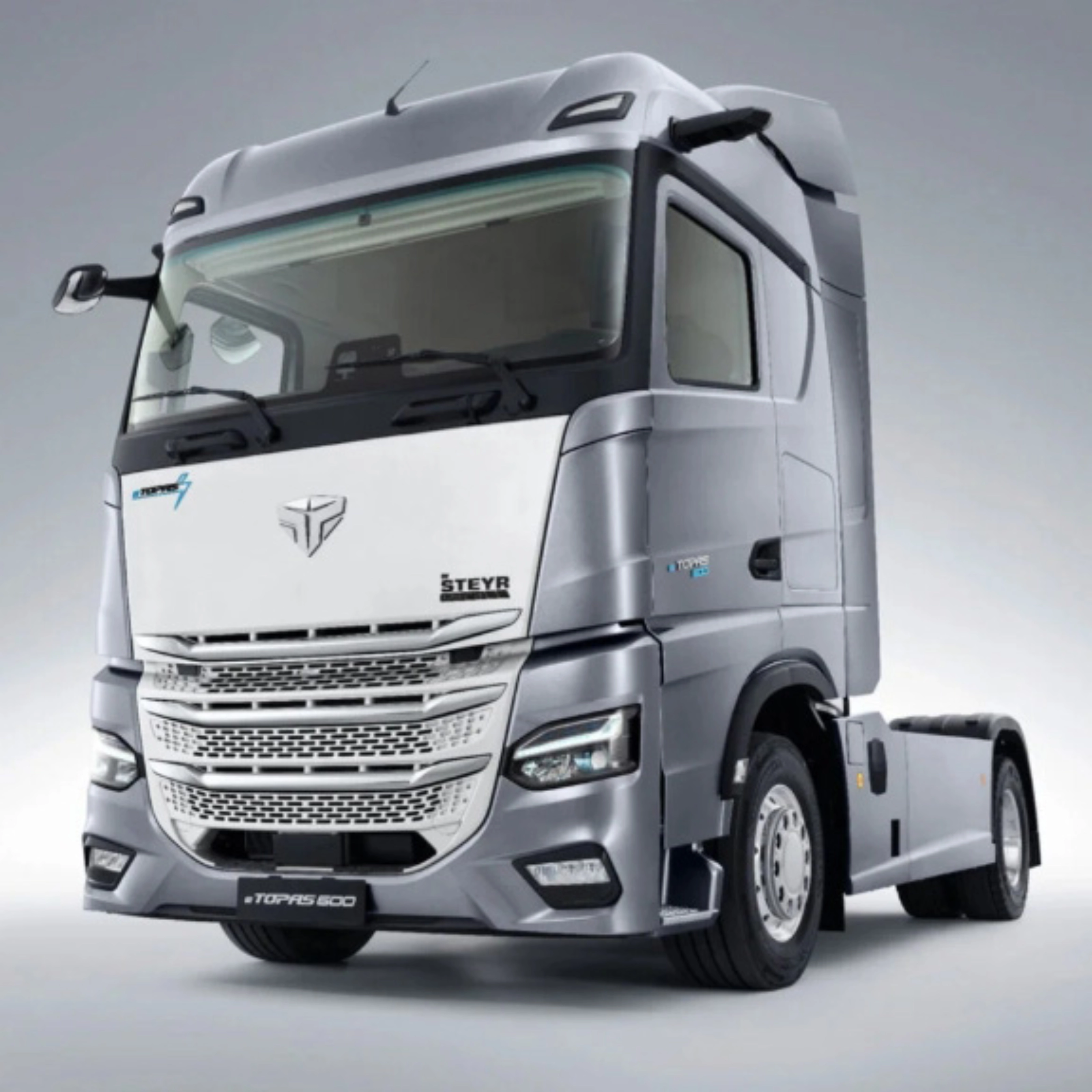 Silver Steyr semi-truck cab in studio view from the front left.