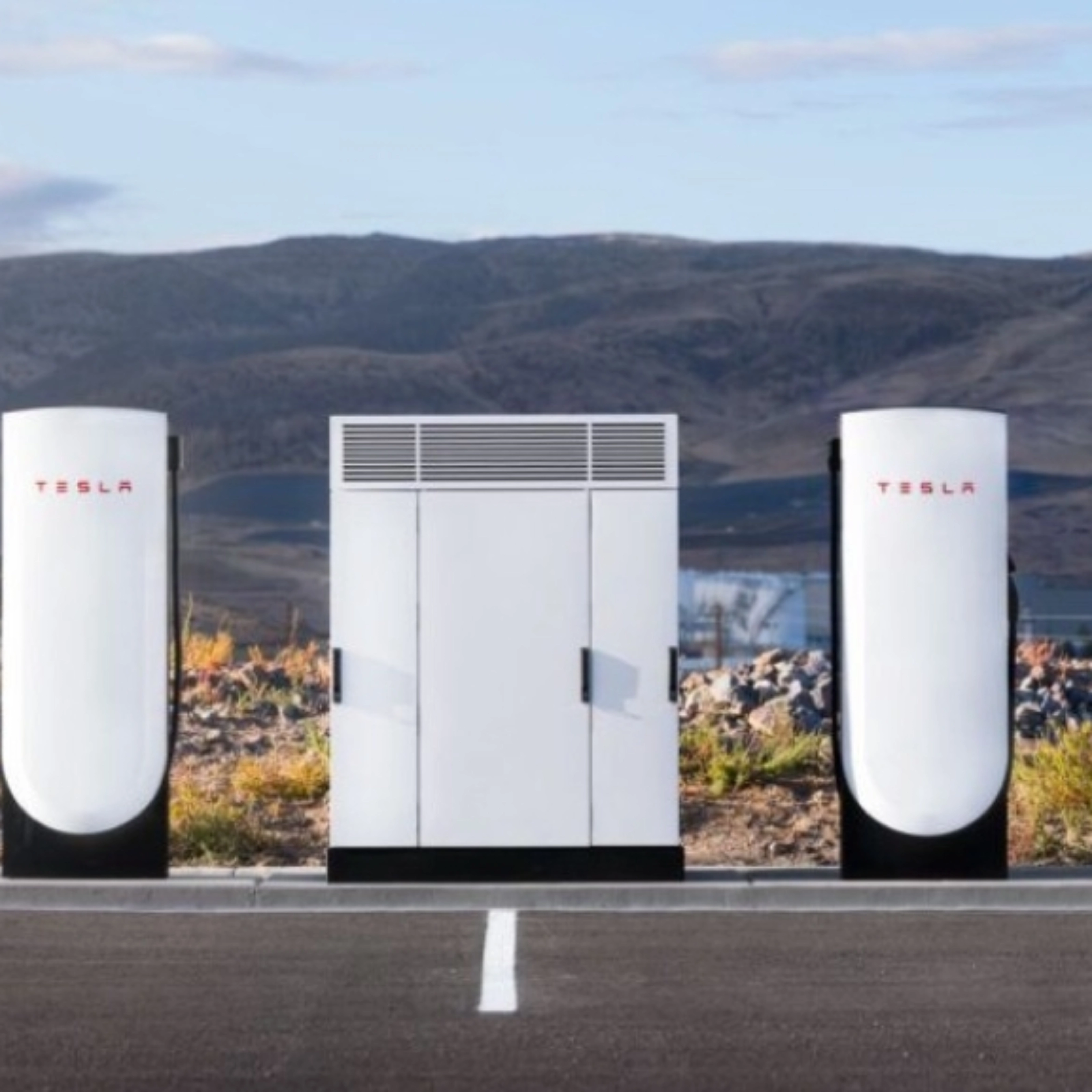 Tesla Supercharger station with two charging posts and a central power unit in a parking lot.