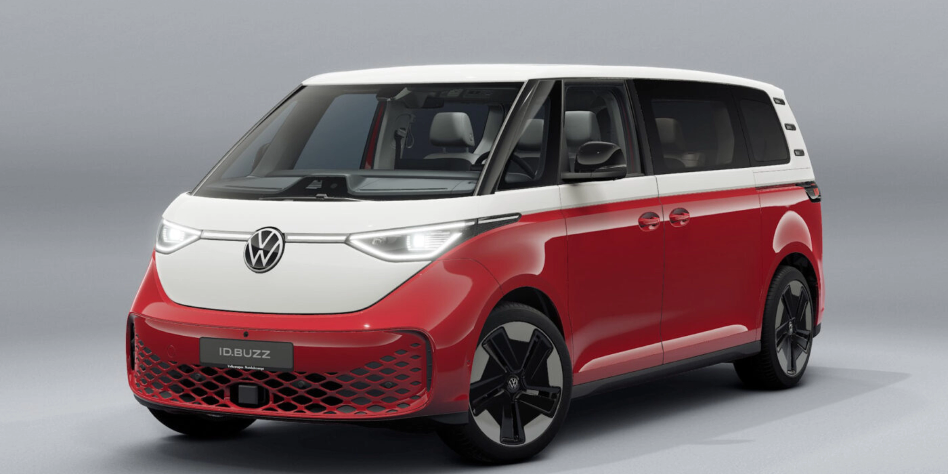Red and white Volkswagen van in front view on a neutral studio background.