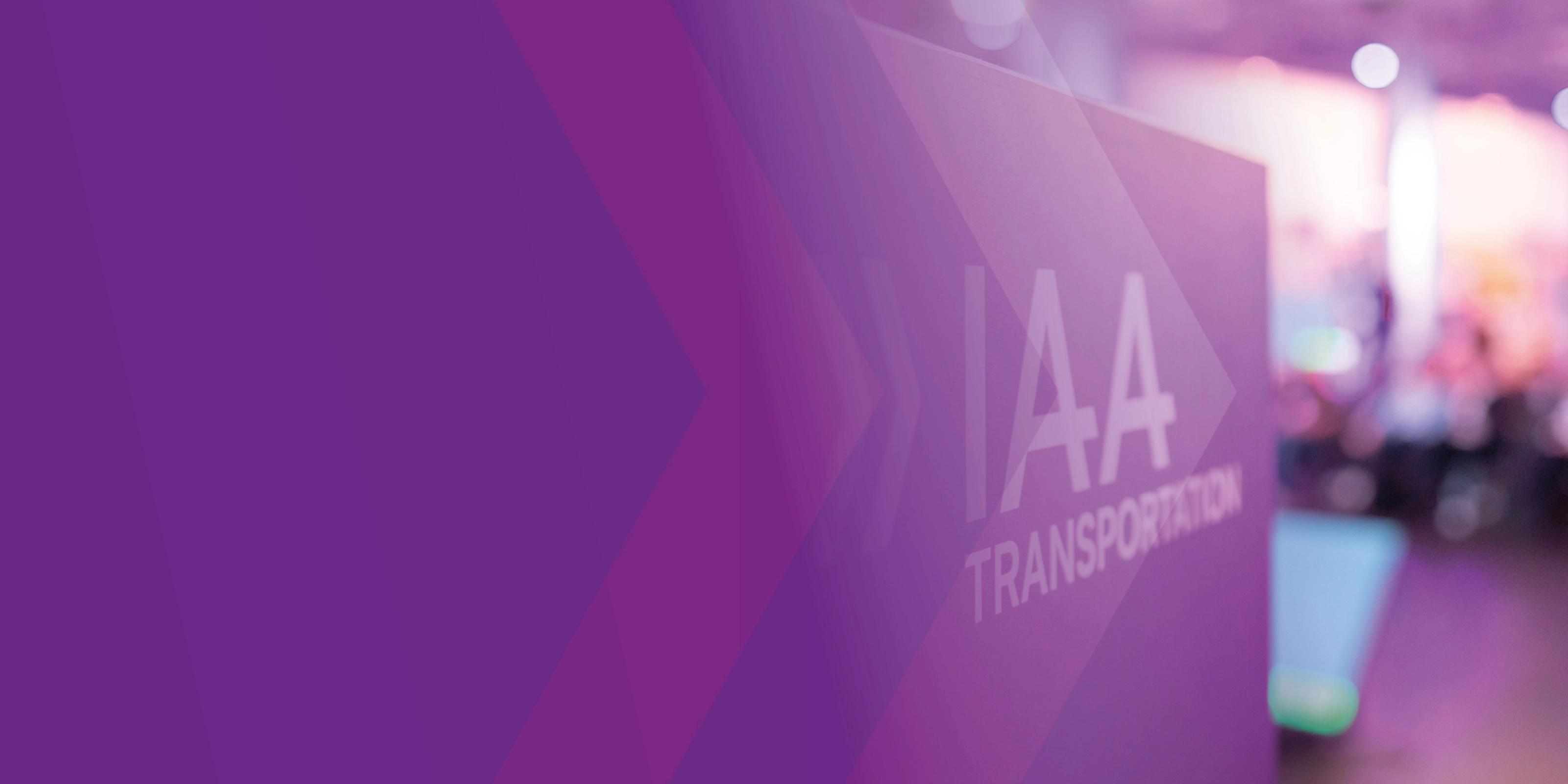 Schild mit der Aufschrift „IAA TRANSPORTATION“ auf einer Messe, lila Gestaltung im Vordergrund.