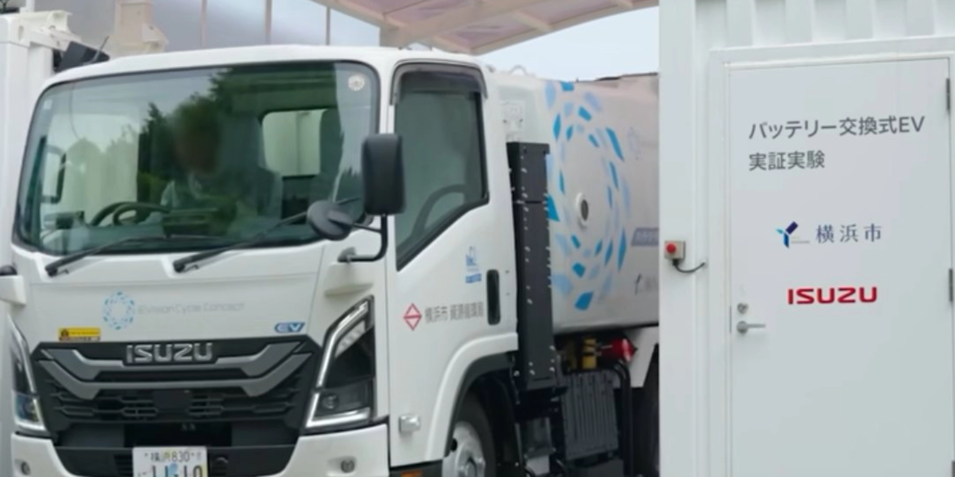 Isuzu truck displayed at an exhibition beside an information board.