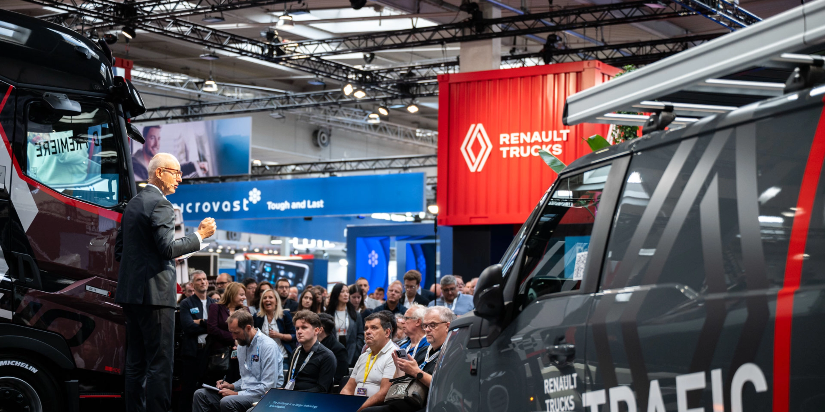 Nutzfahrzeuge und Besucher in einer gut besuchten Messehalle der IAA Transportation.