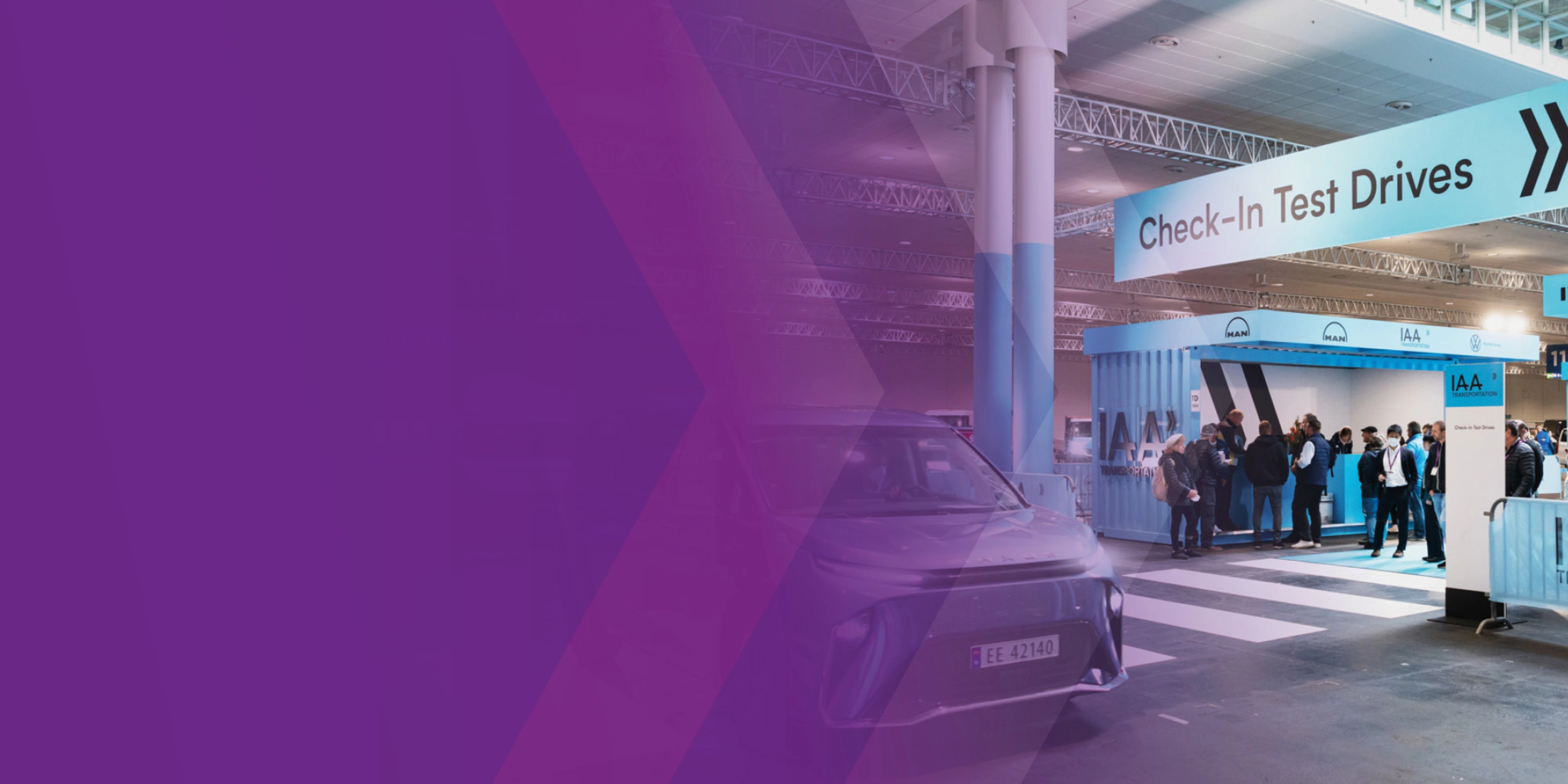 Check‑in‑Bereich für Probefahrten der IAA Transportation mit Fahrzeug und Personen in einer Halle.