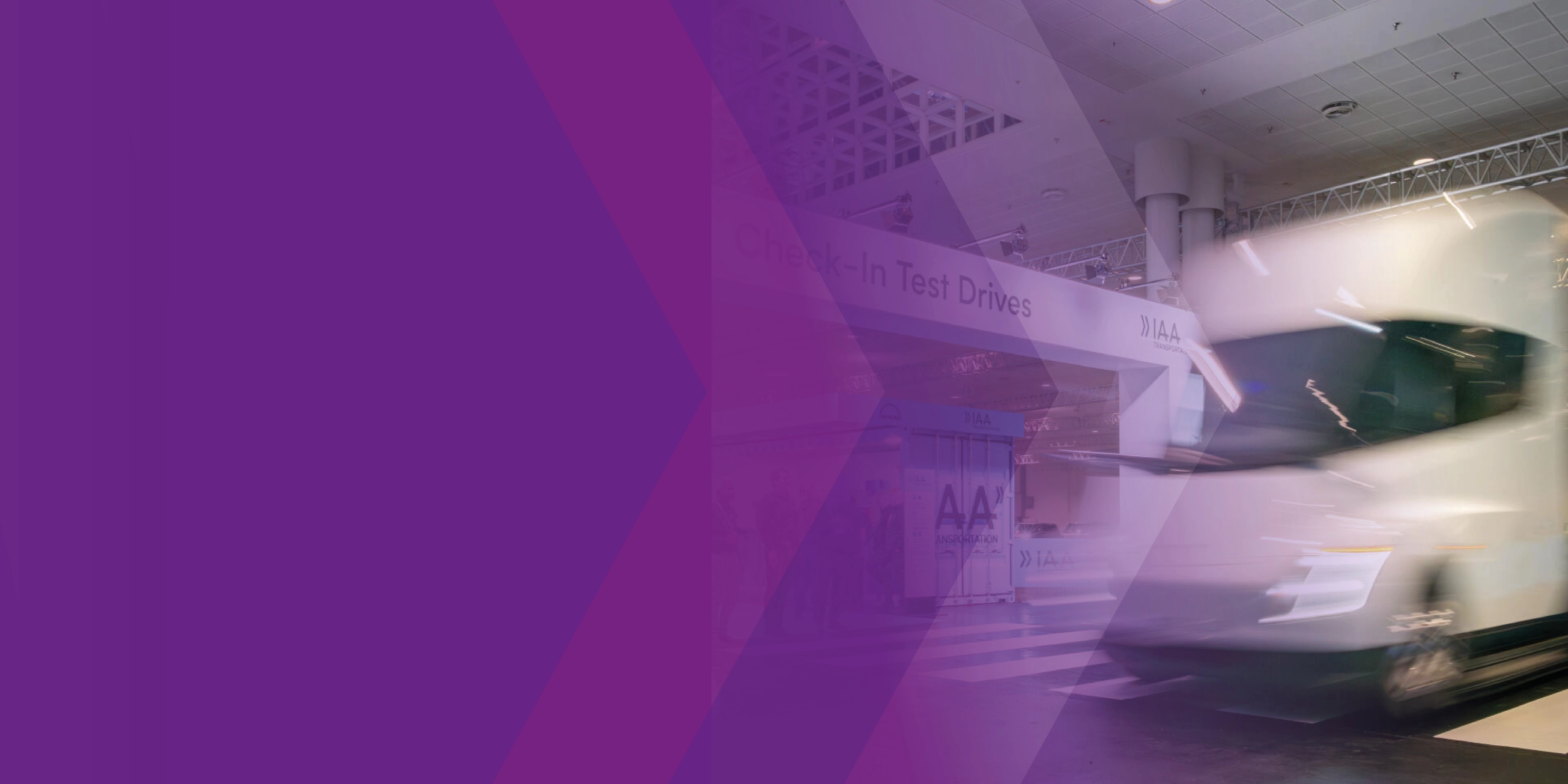 Blurred white truck at the IAA test drive area with a purple graphic overlay.