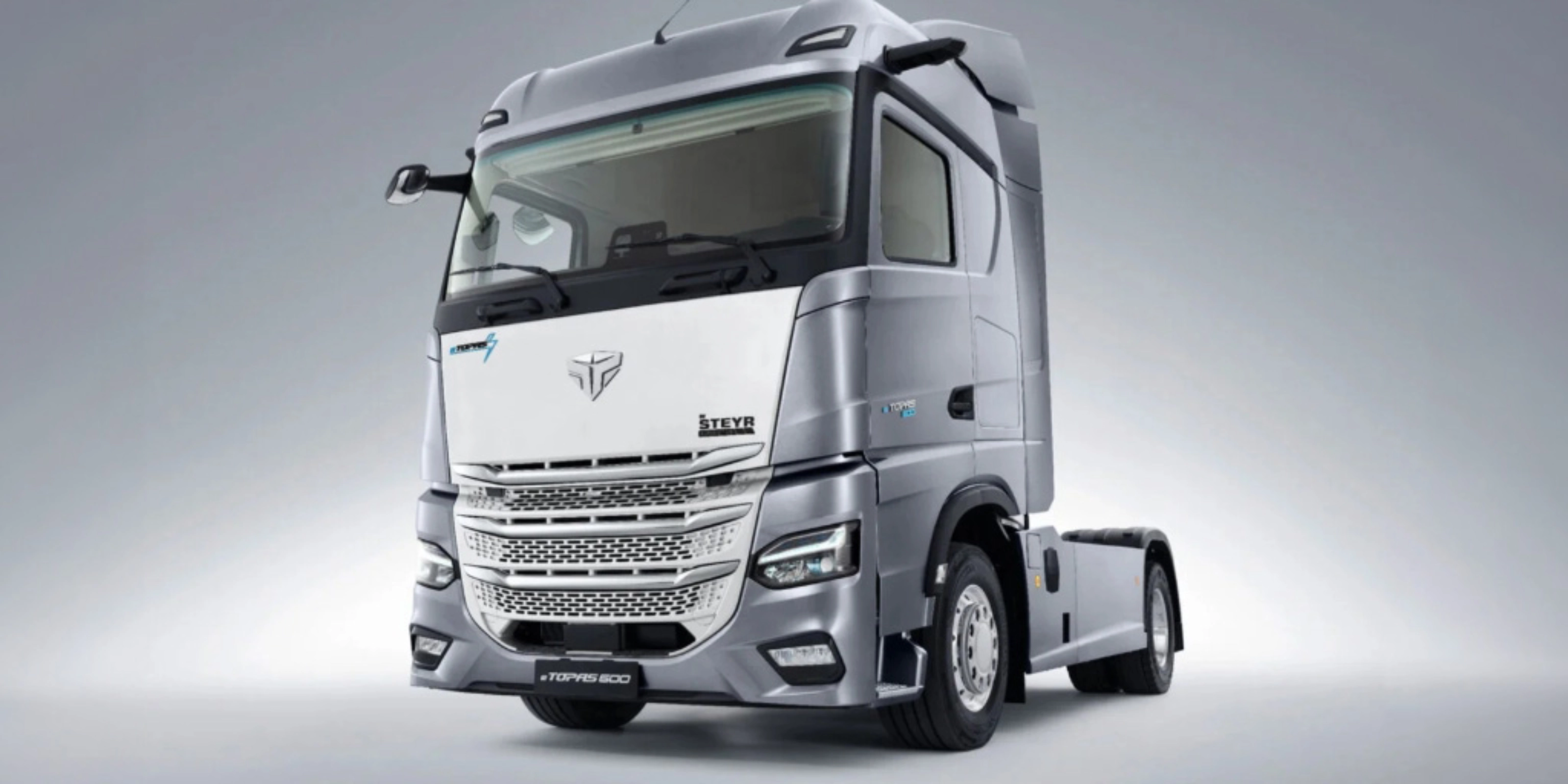 Silver Steyr semi-truck cab in studio view from the front left.