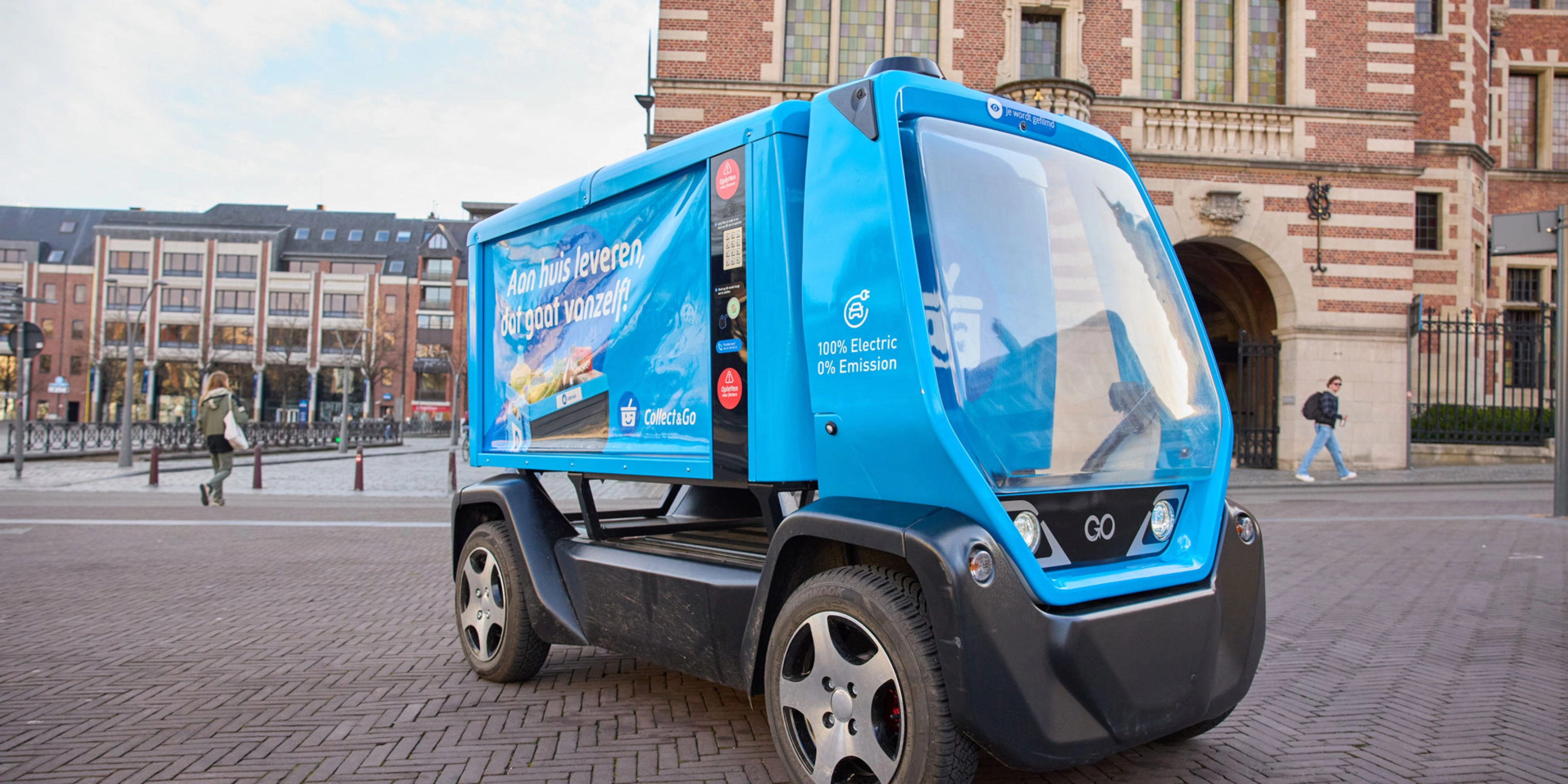 Kleines blaues Elektro-Müllfahrzeug auf einem Stadtplatz.