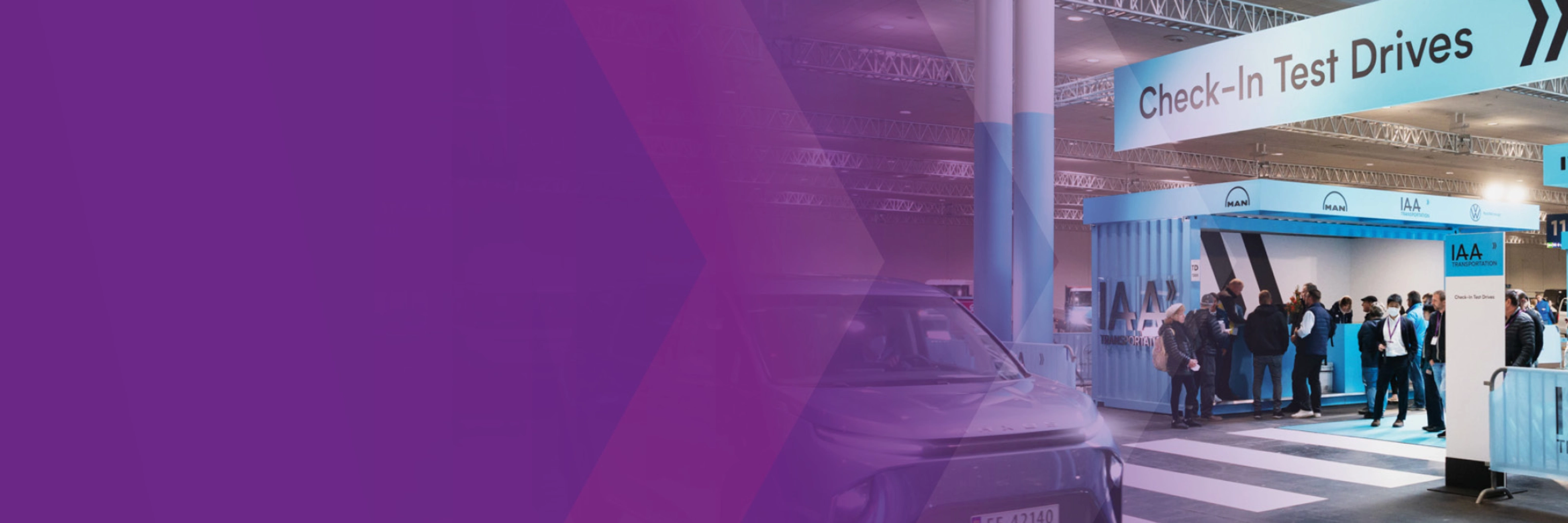 Check‑in‑Bereich für Probefahrten der IAA Transportation mit Fahrzeug und Personen in einer Halle.