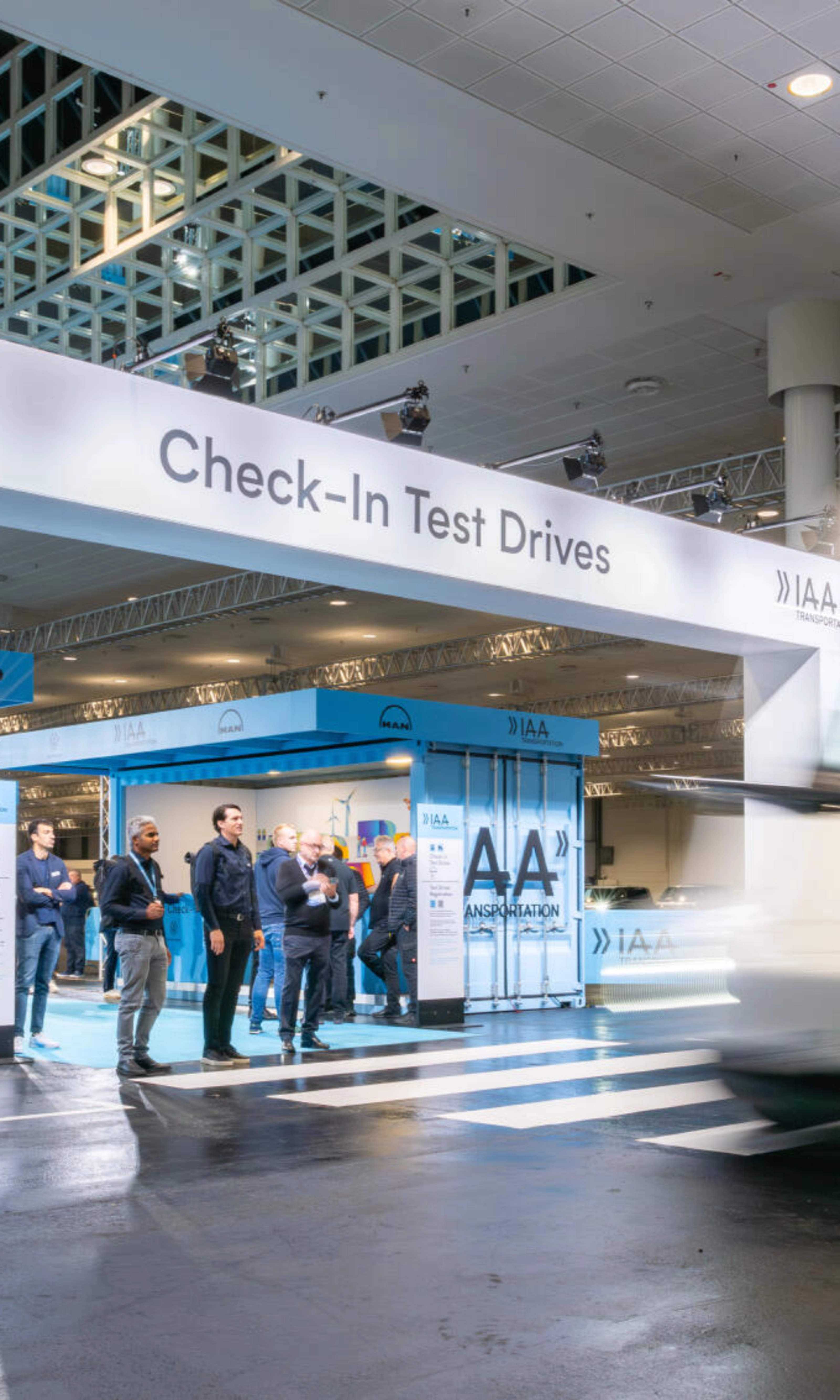 IAA Transportation Check-In area for test drives with truck passing by.