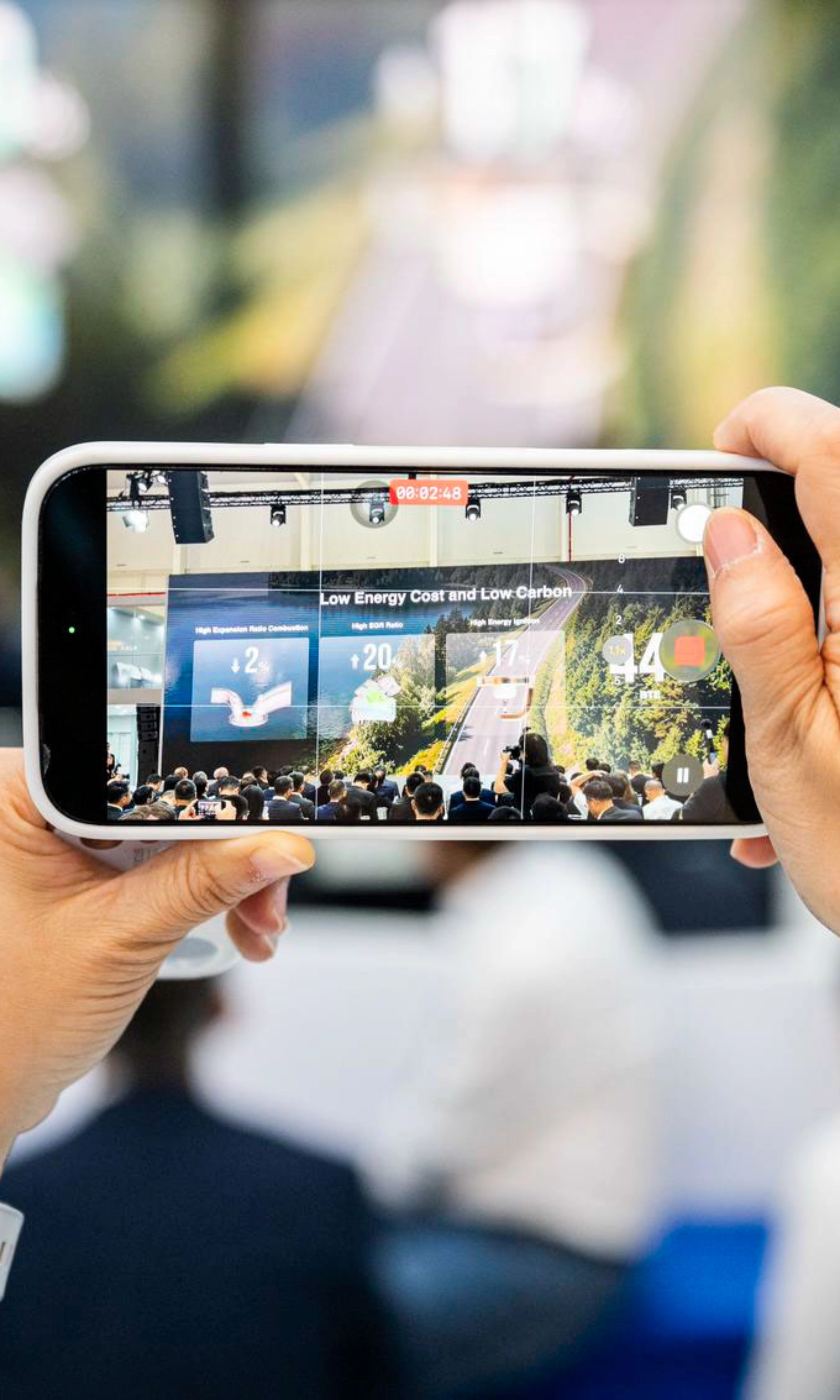 Person taking a photo of an event with a smartphone.