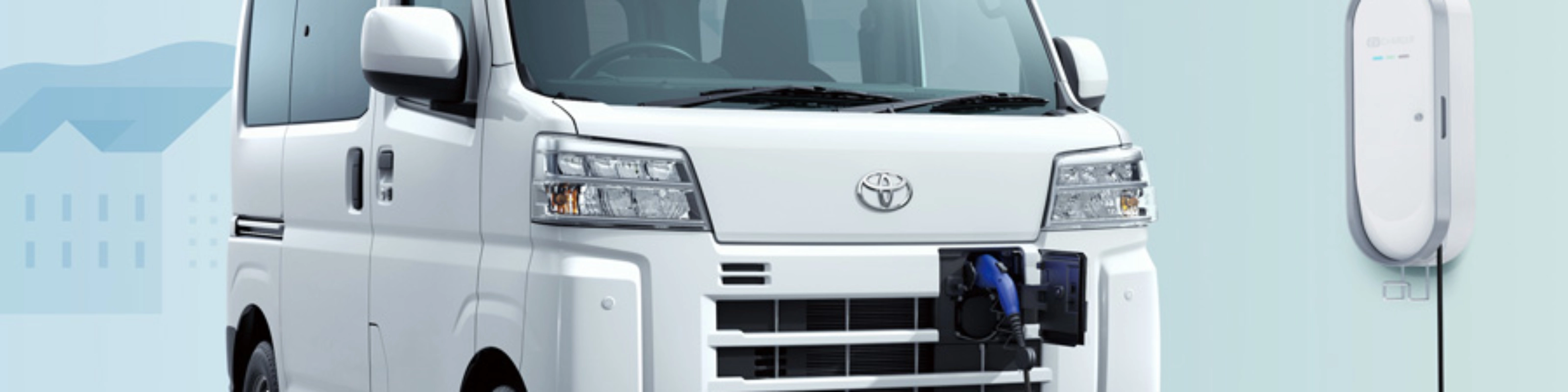 Electric van labeled "Pixis Van" is charging at a wall-mounted station via front charging port.