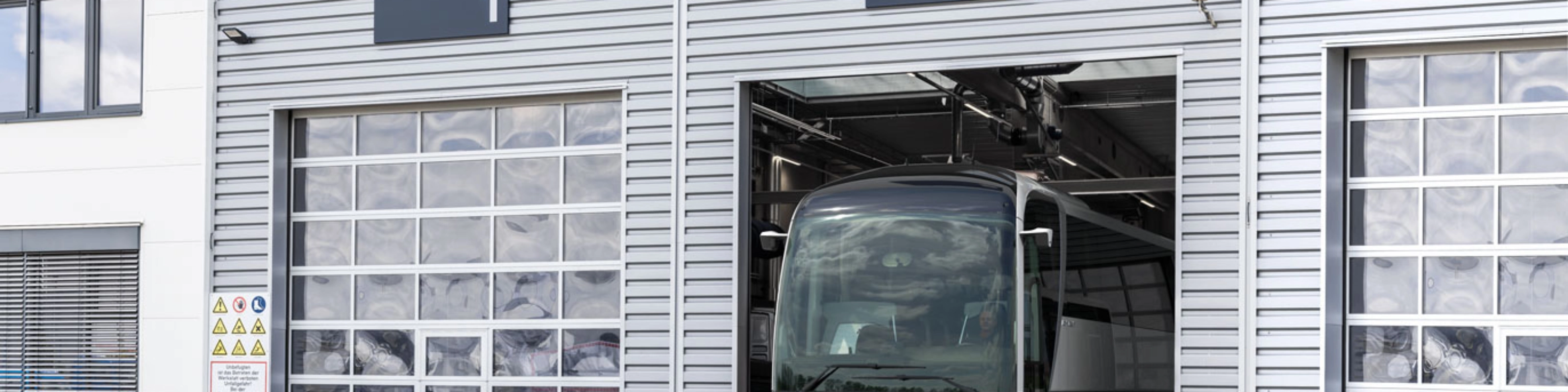 Ein Bus steht in einer nummerierten Garage eines modernen Betriebsgebäudes.