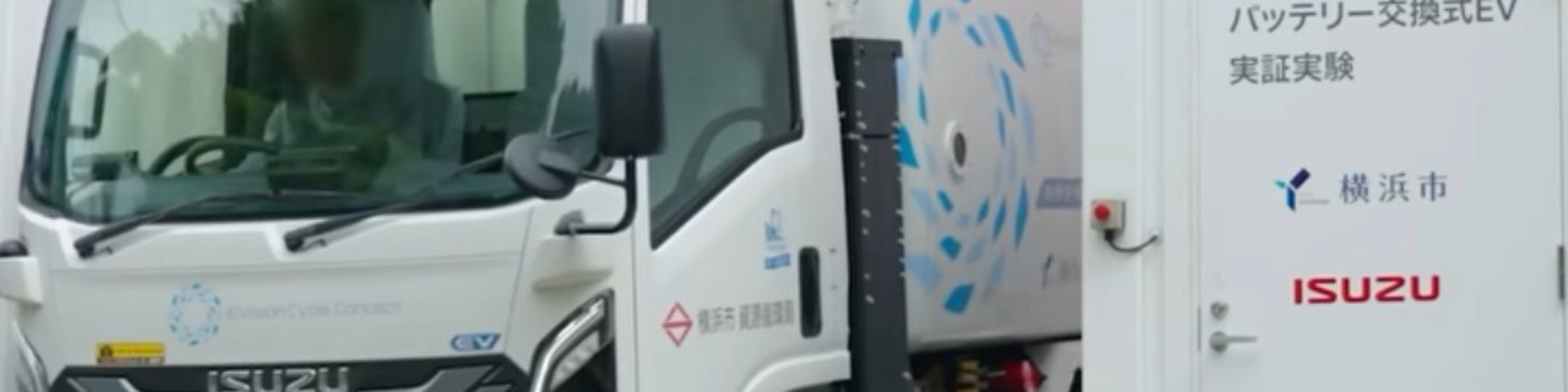 Isuzu truck displayed at an exhibition beside an information board.