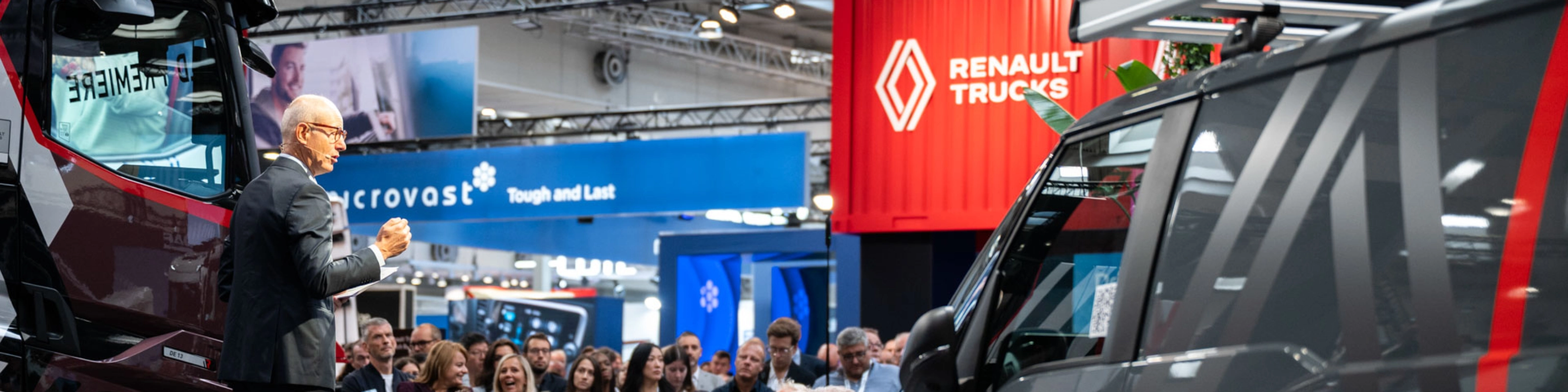 Nutzfahrzeuge und Besucher in einer gut besuchten Messehalle der IAA Transportation.