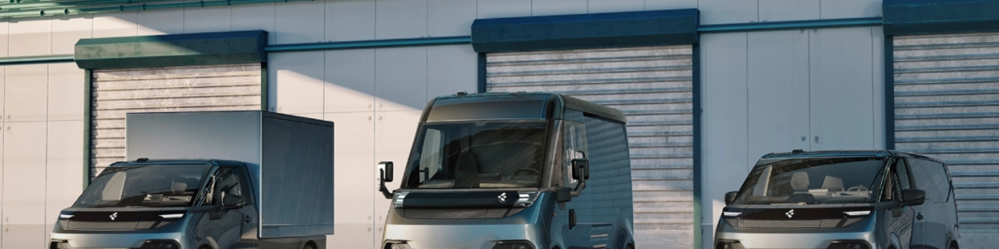 Three FLEXIS electric delivery vans parked in front of a warehouse.