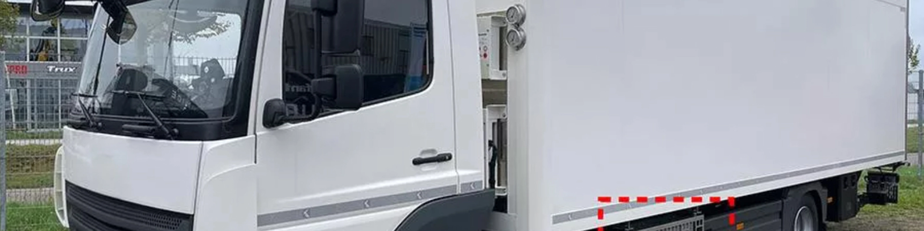 Weißer Mitsubishi Heavy Industries Koffer-Lkw mit seitlich montierten TEU-Boxen.