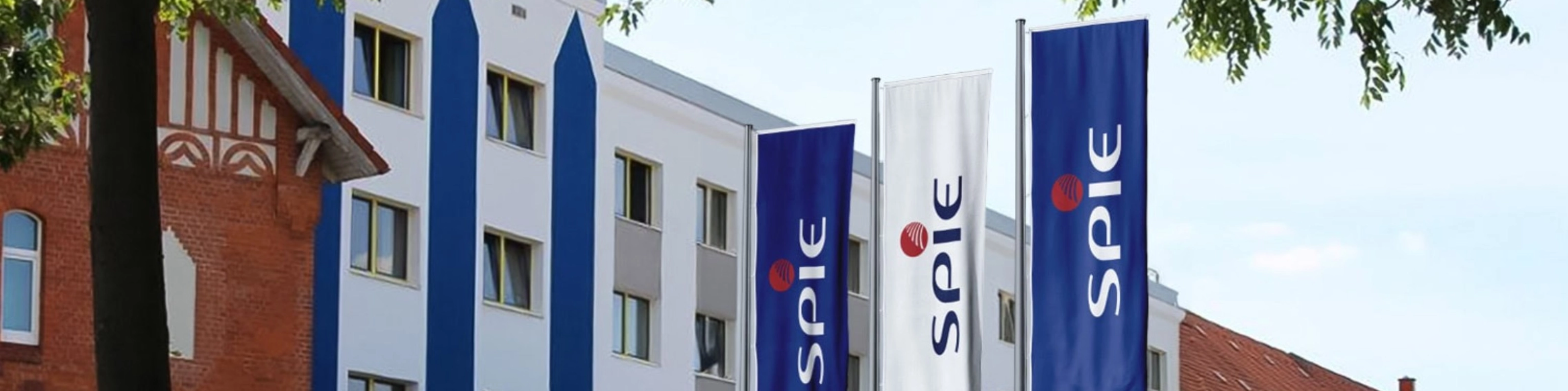 SPIE company building with blue SPIE flags displayed along the facade.
