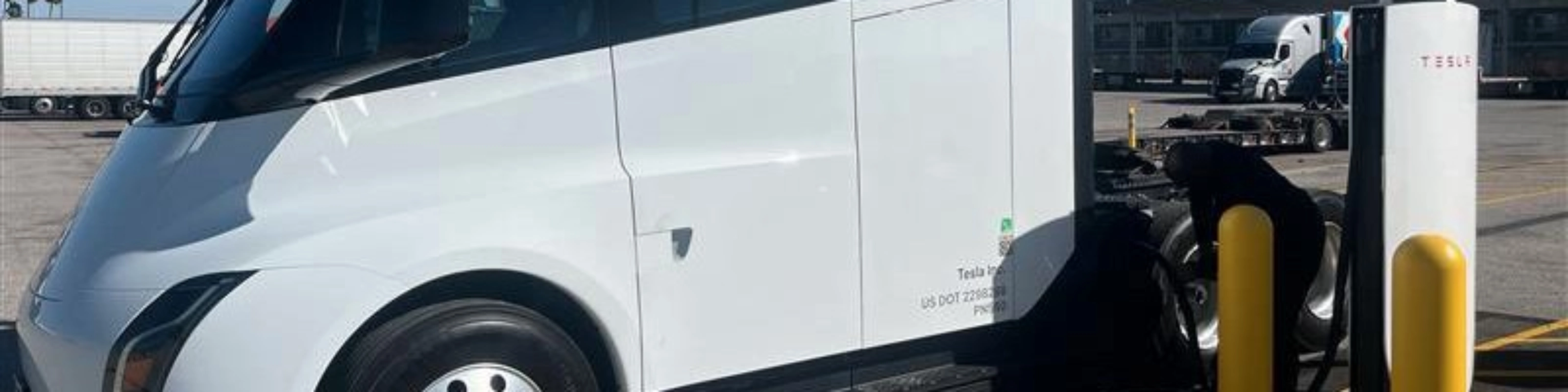 White Tesla Semi charging at a Tesla charging station.