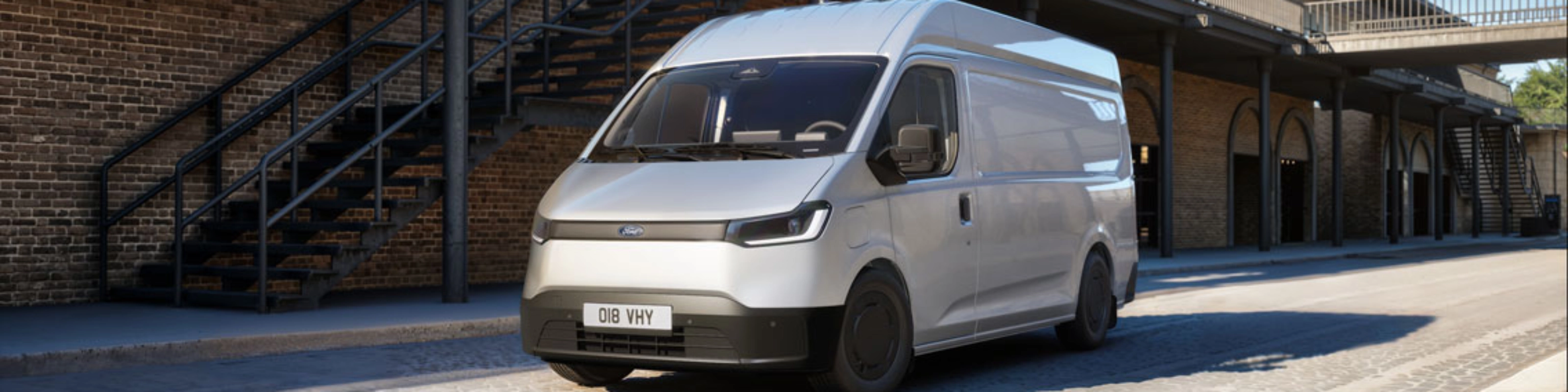 White van parked in a courtyard in front of a brick building