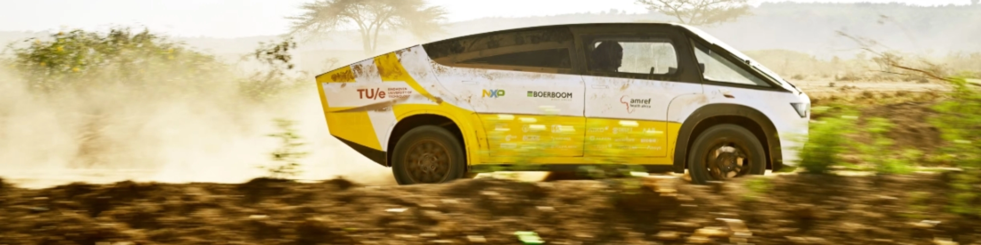 Fahrzeug des Solar Team Eindhoven fährt auf einer staubigen unbefestigten Straße.